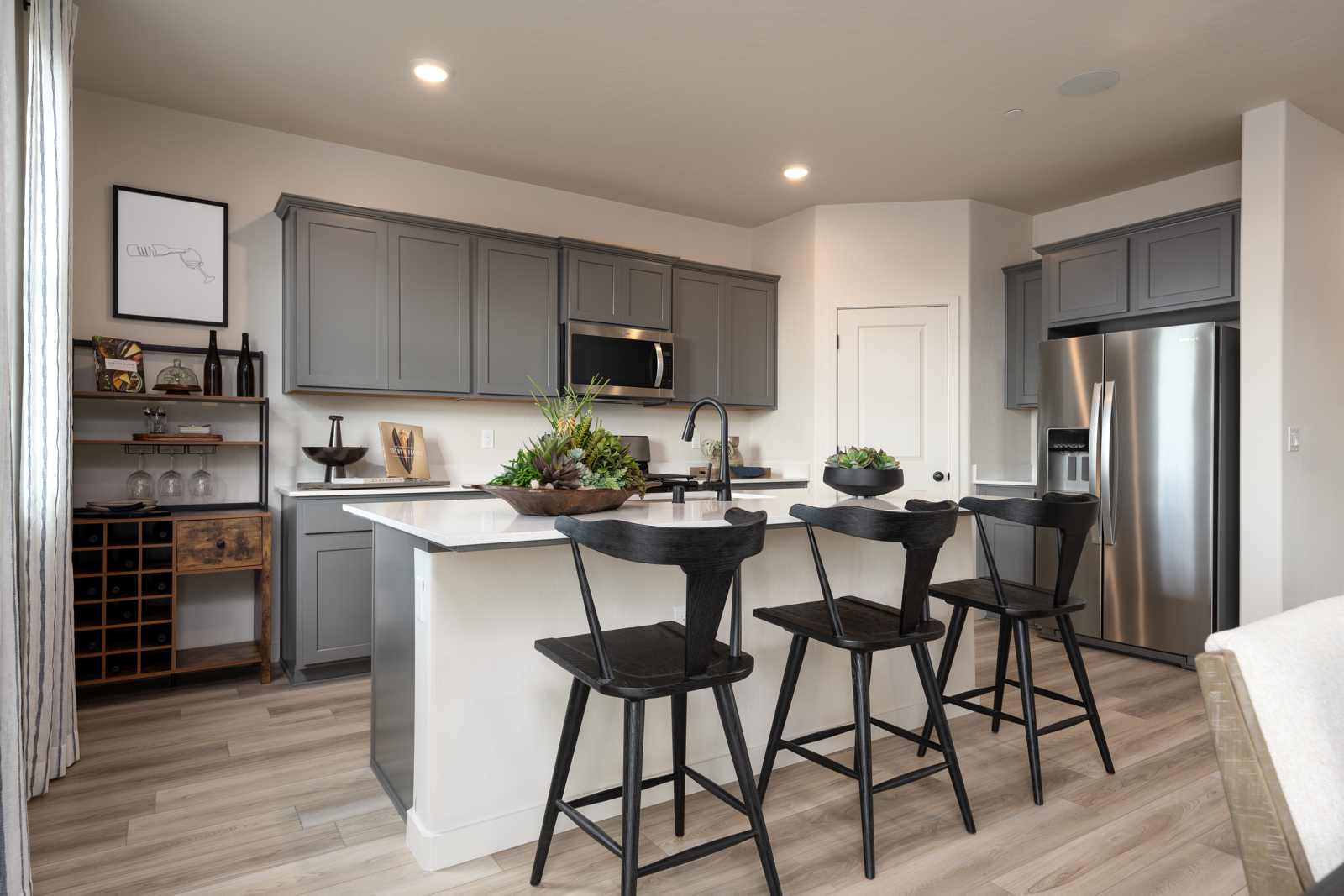 A kitchen with black chairs.