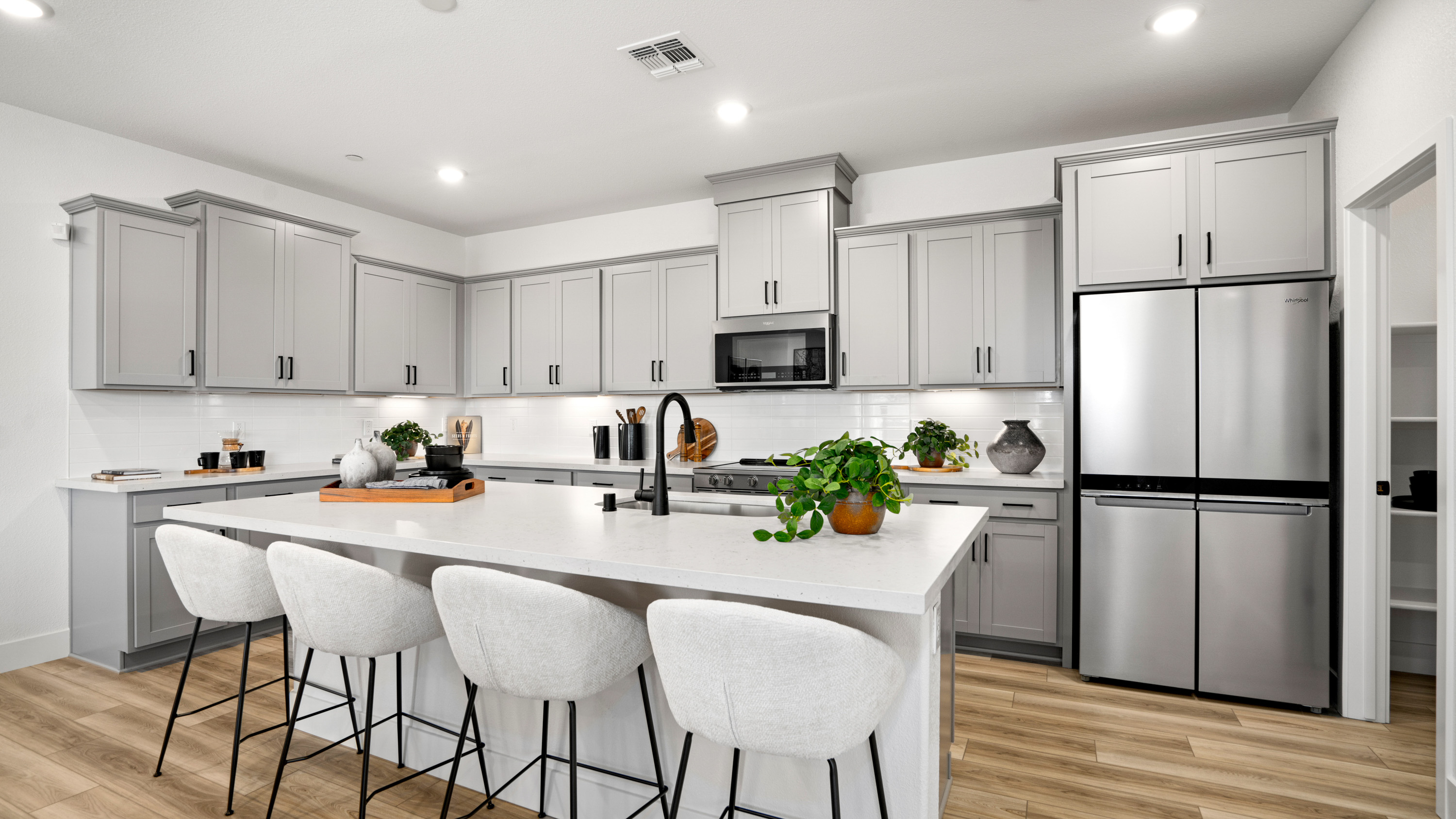 A kitchen with white cabinets.
