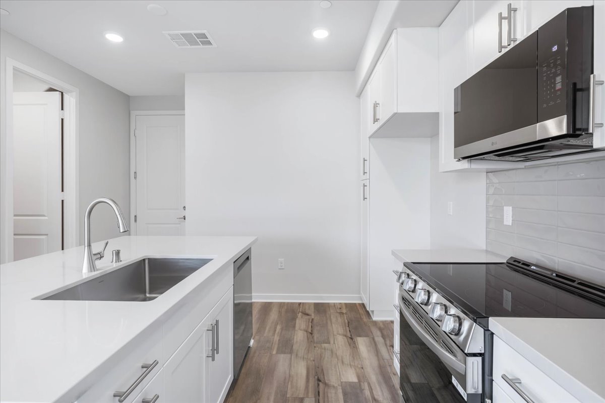 A kitchen with white cabinets.