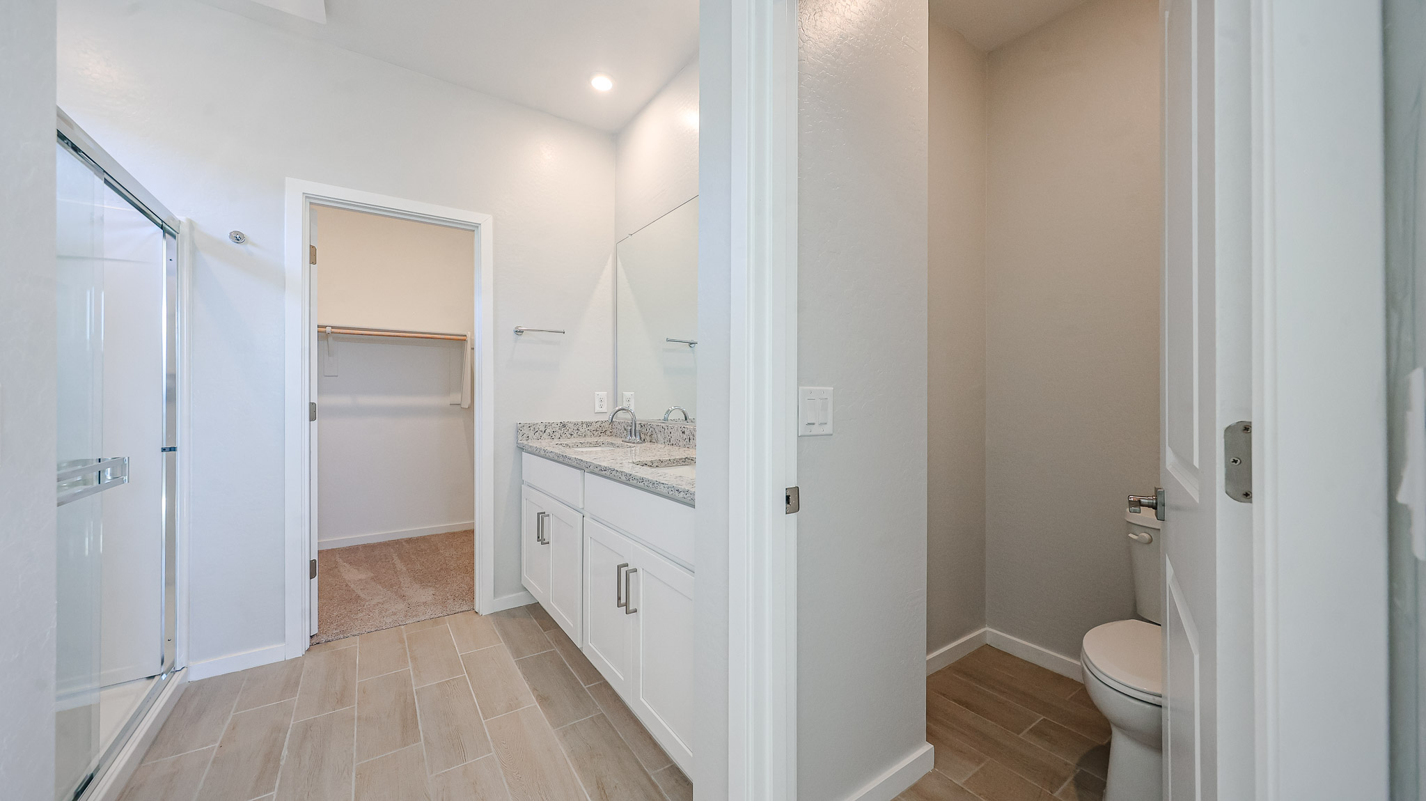 A bathroom with a shower unit and toilet.