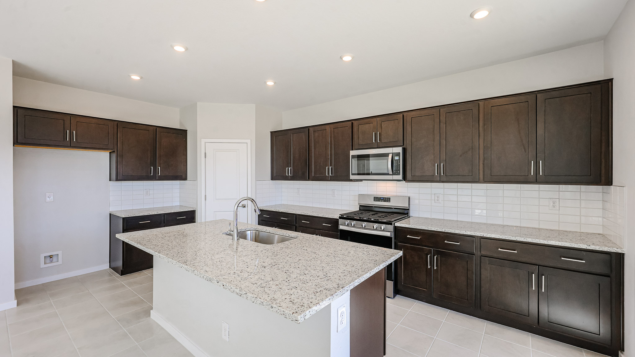 A kitchen with dark wood cabinets.