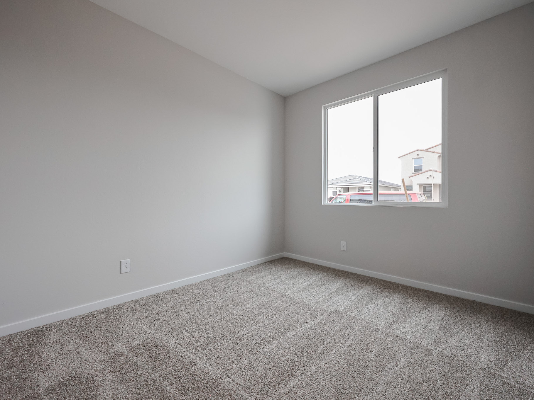 A room with a window and carpet.