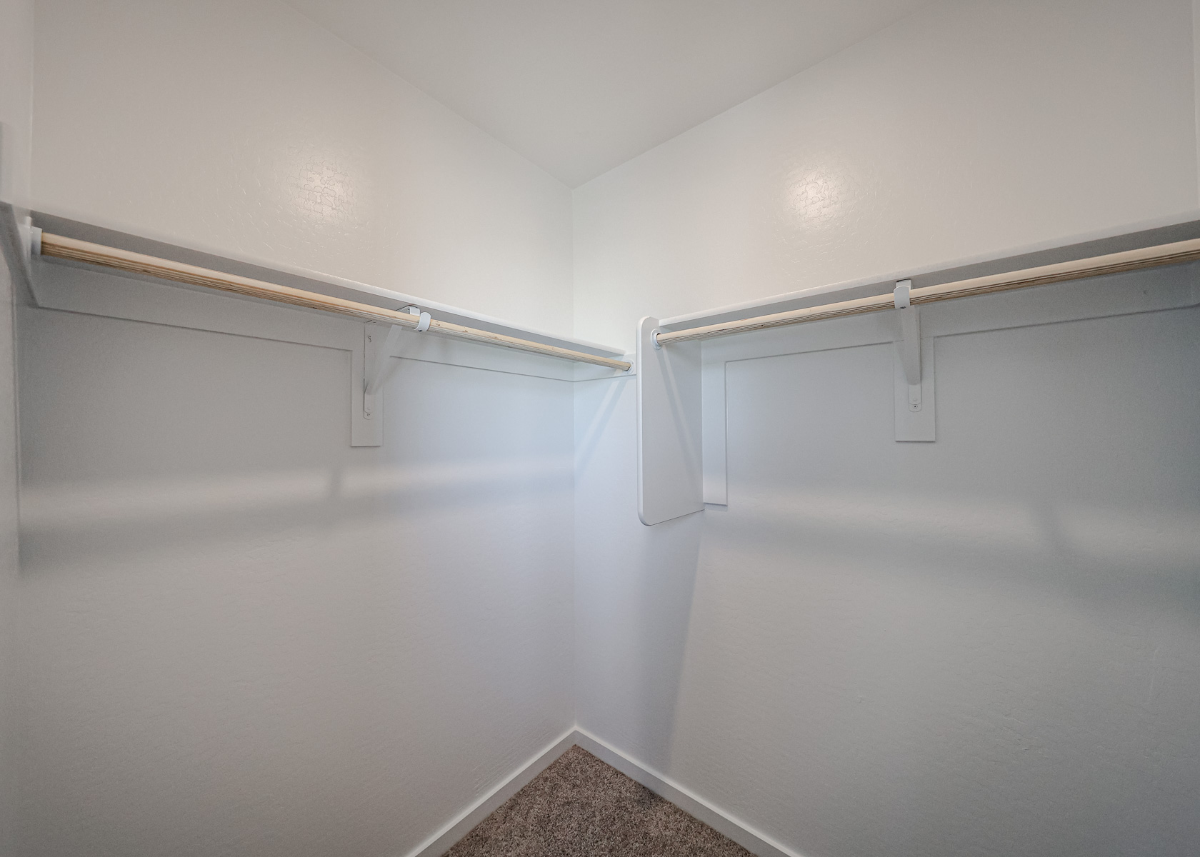 A white wall with a metal bar.