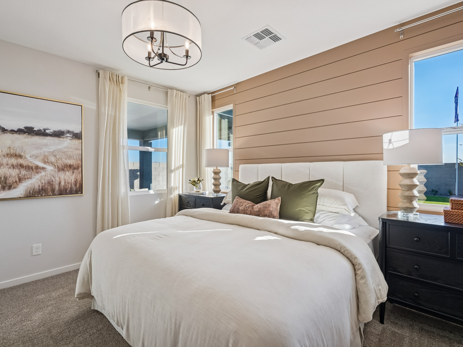 A bedroom with a bed and lamps.