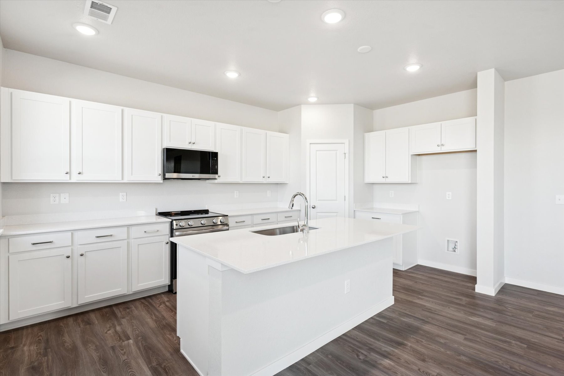 A kitchen with white cabinets.