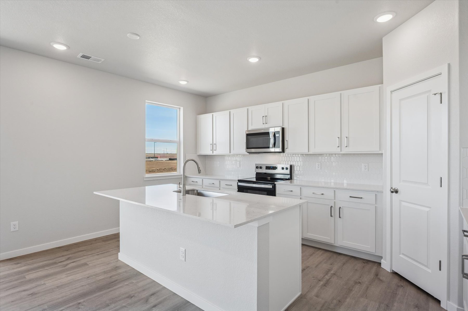 A kitchen with white cabinets.