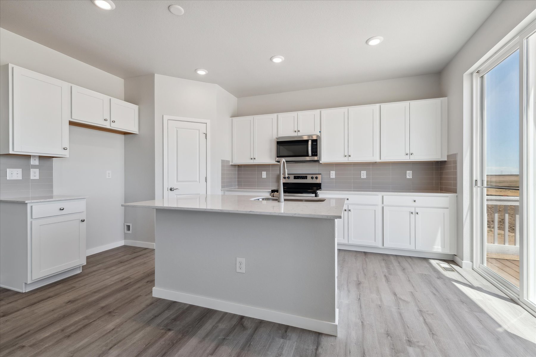 A kitchen with white cabinets.