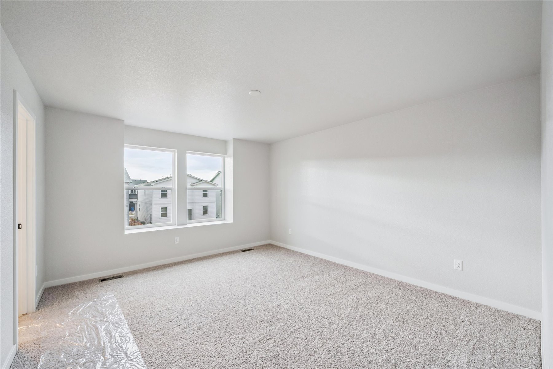 A room with a window and a carpet.