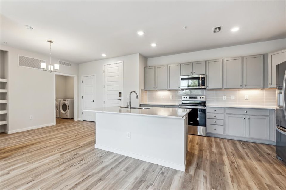 A kitchen with white cabinets.