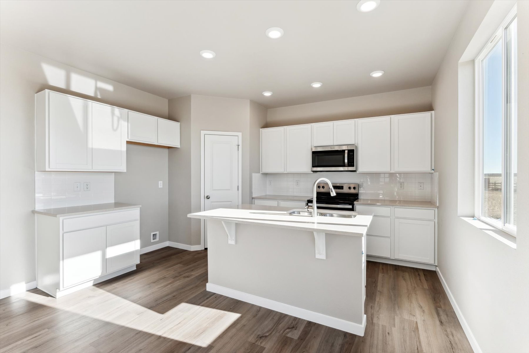 A kitchen with white cabinets.