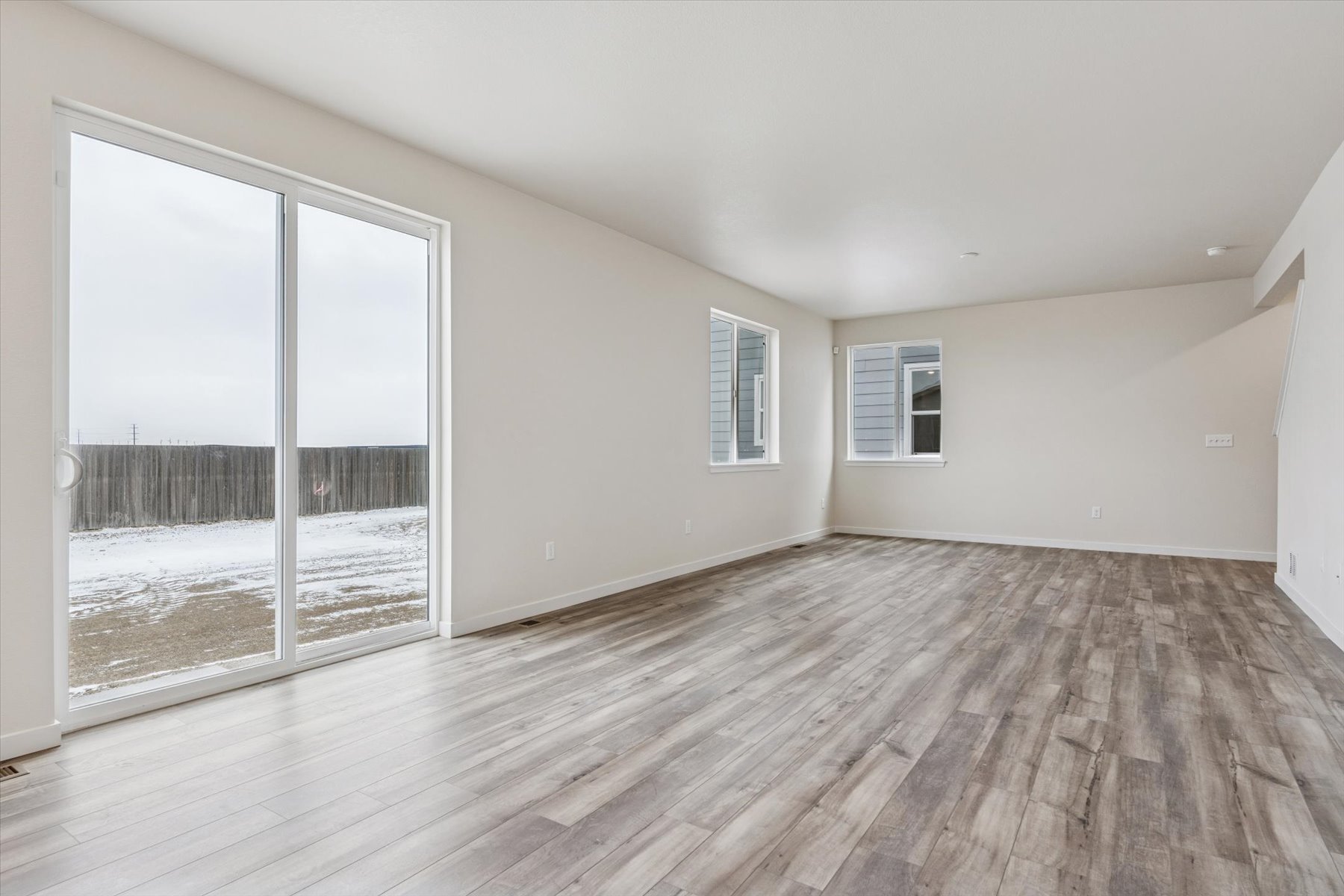 A room with a wood floor and a glass door.