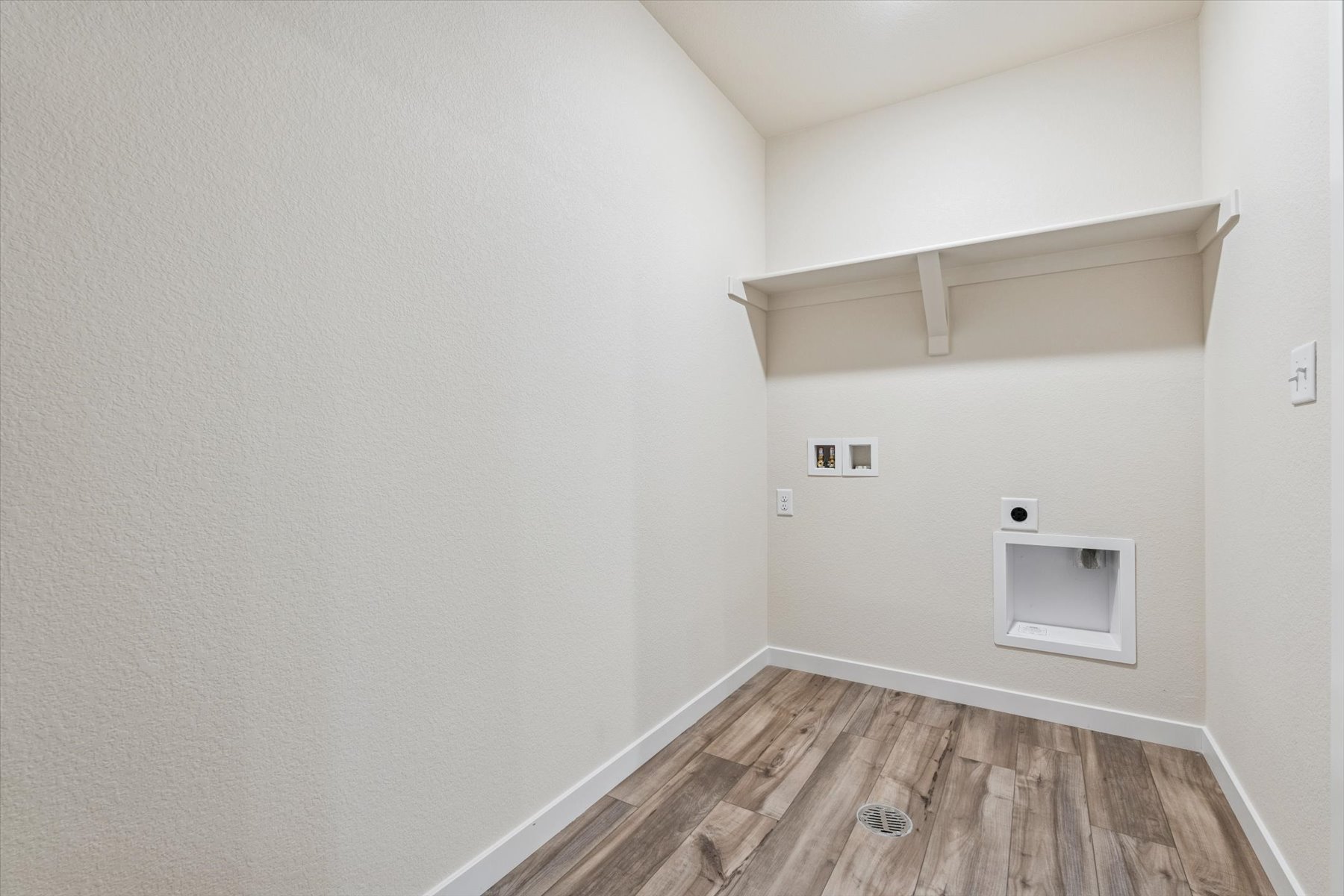 A room with a wood floor and white walls.