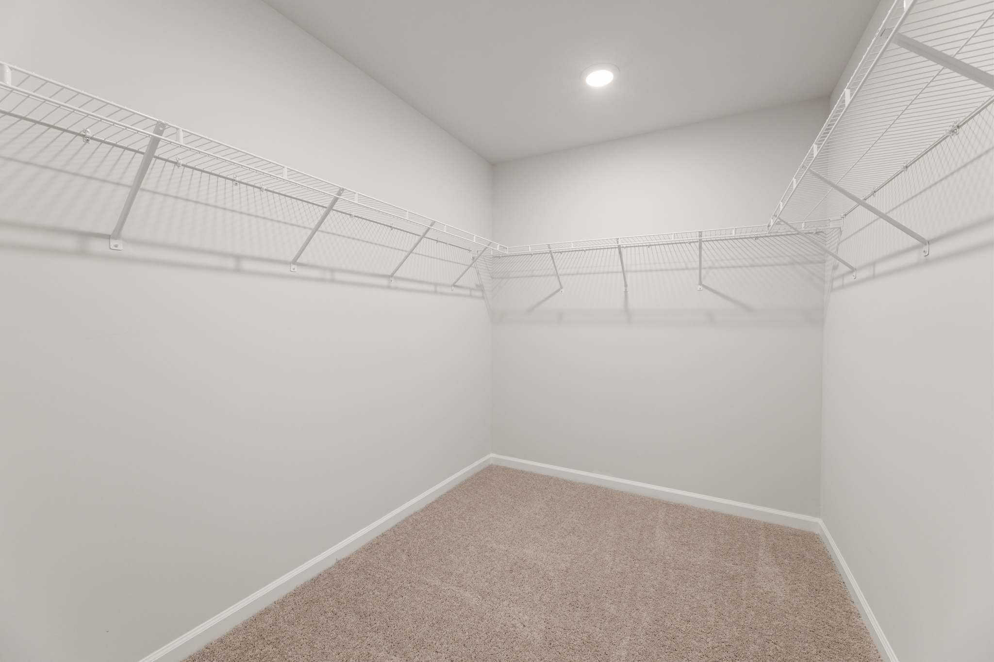 A white hallway with a metal railing.