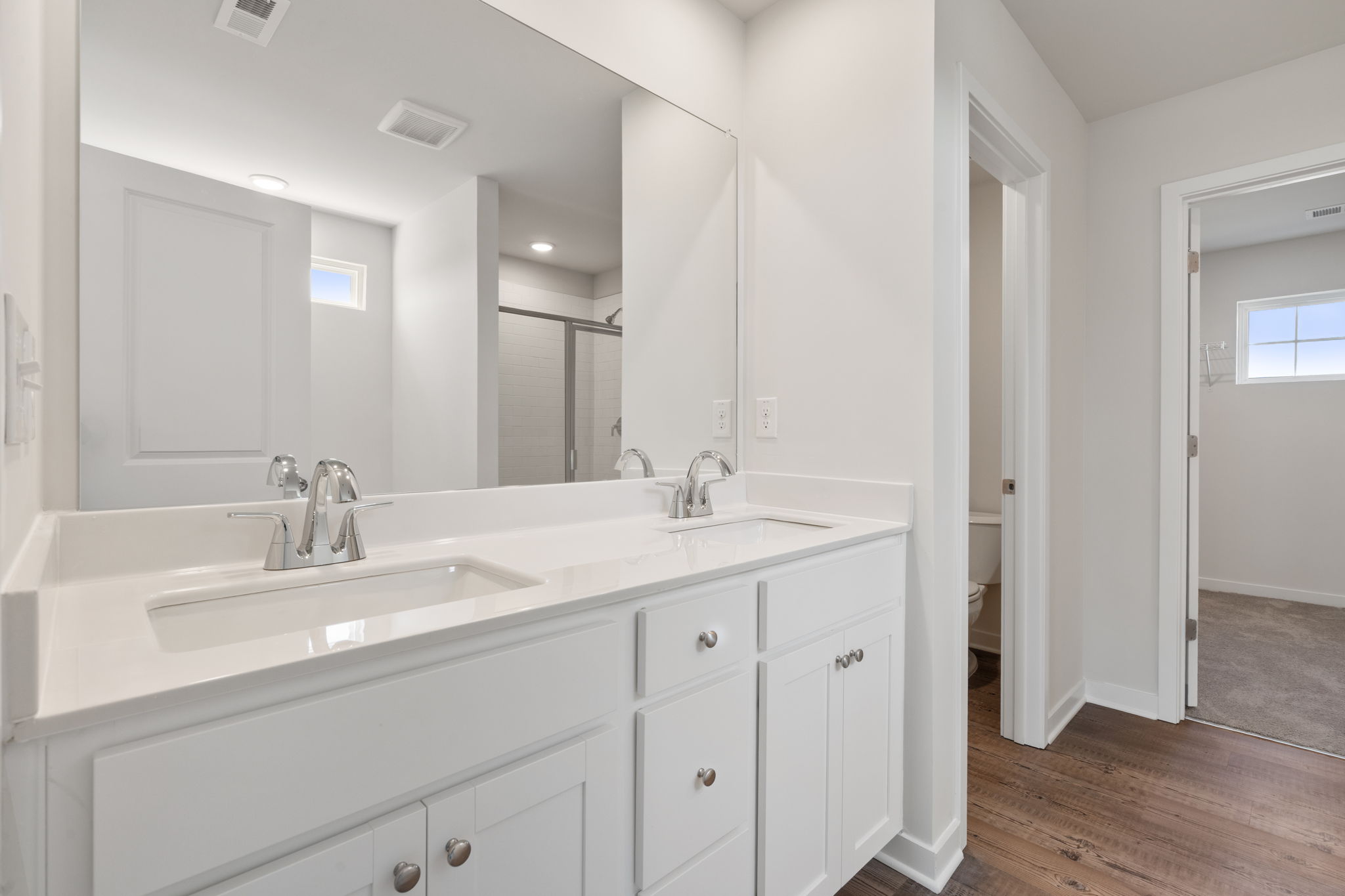 A bathroom with white cabinets.