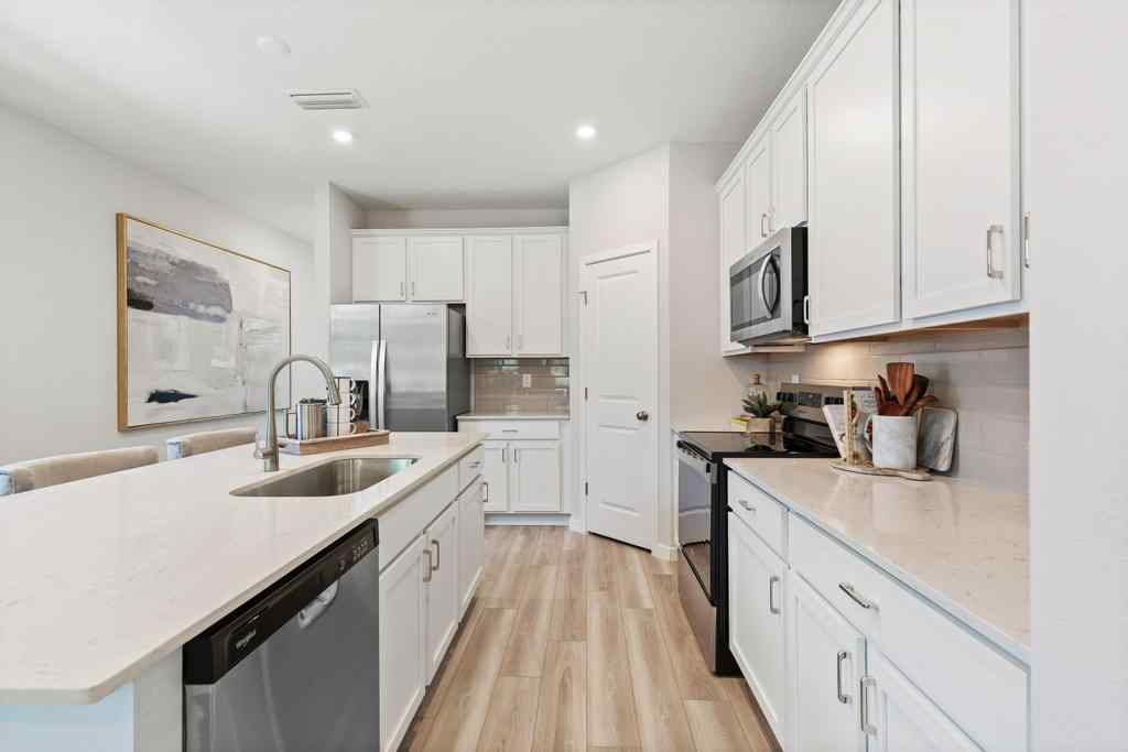 A kitchen with white cabinets.