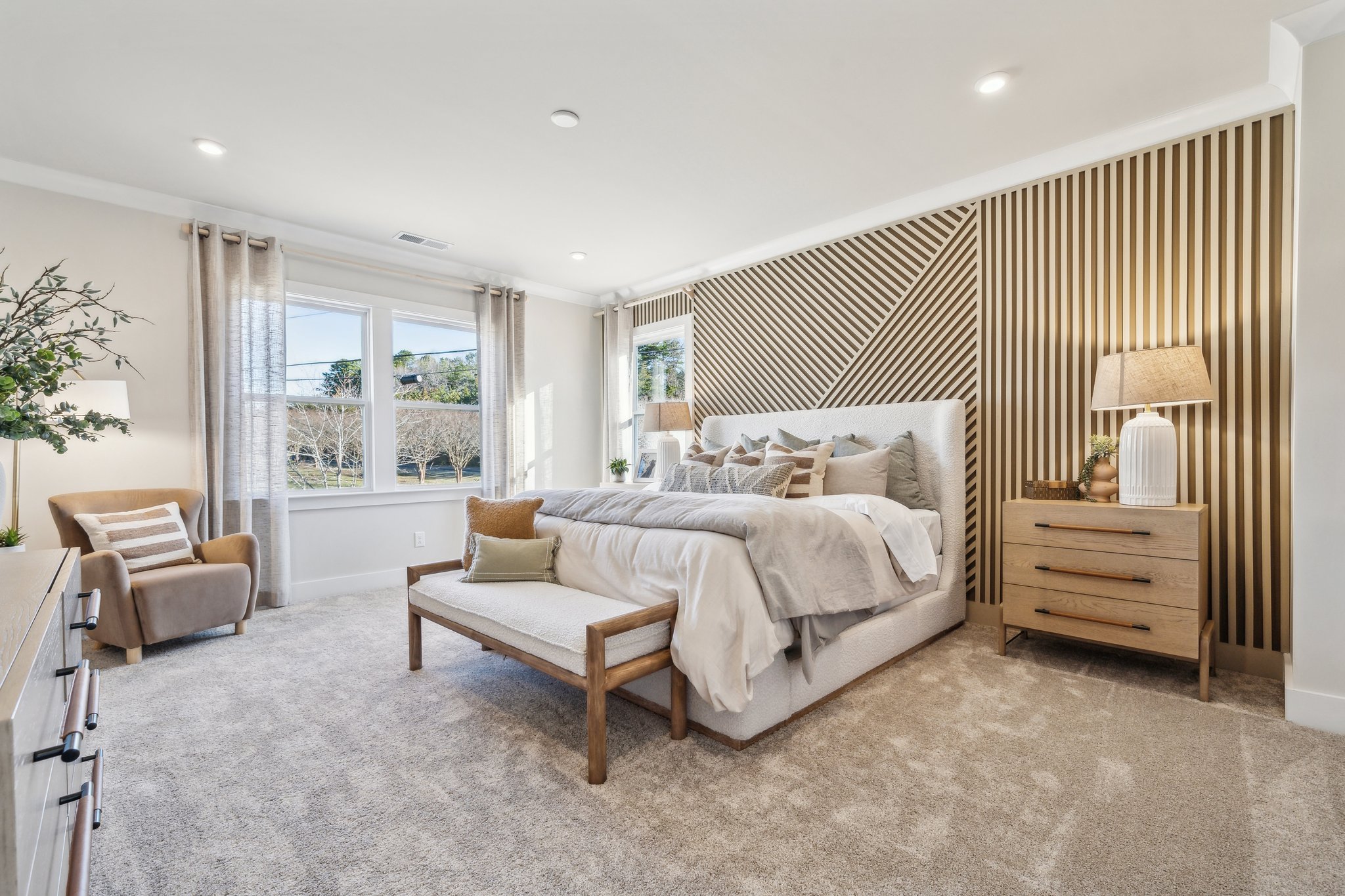 A bedroom with a bed and a bench.