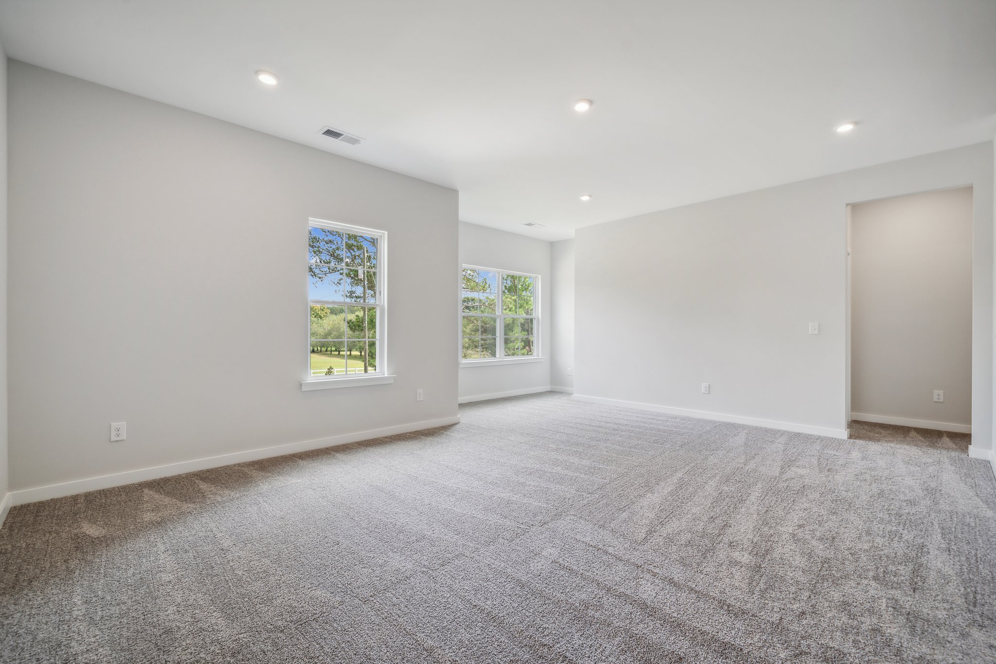 A room with a carpet and a window.