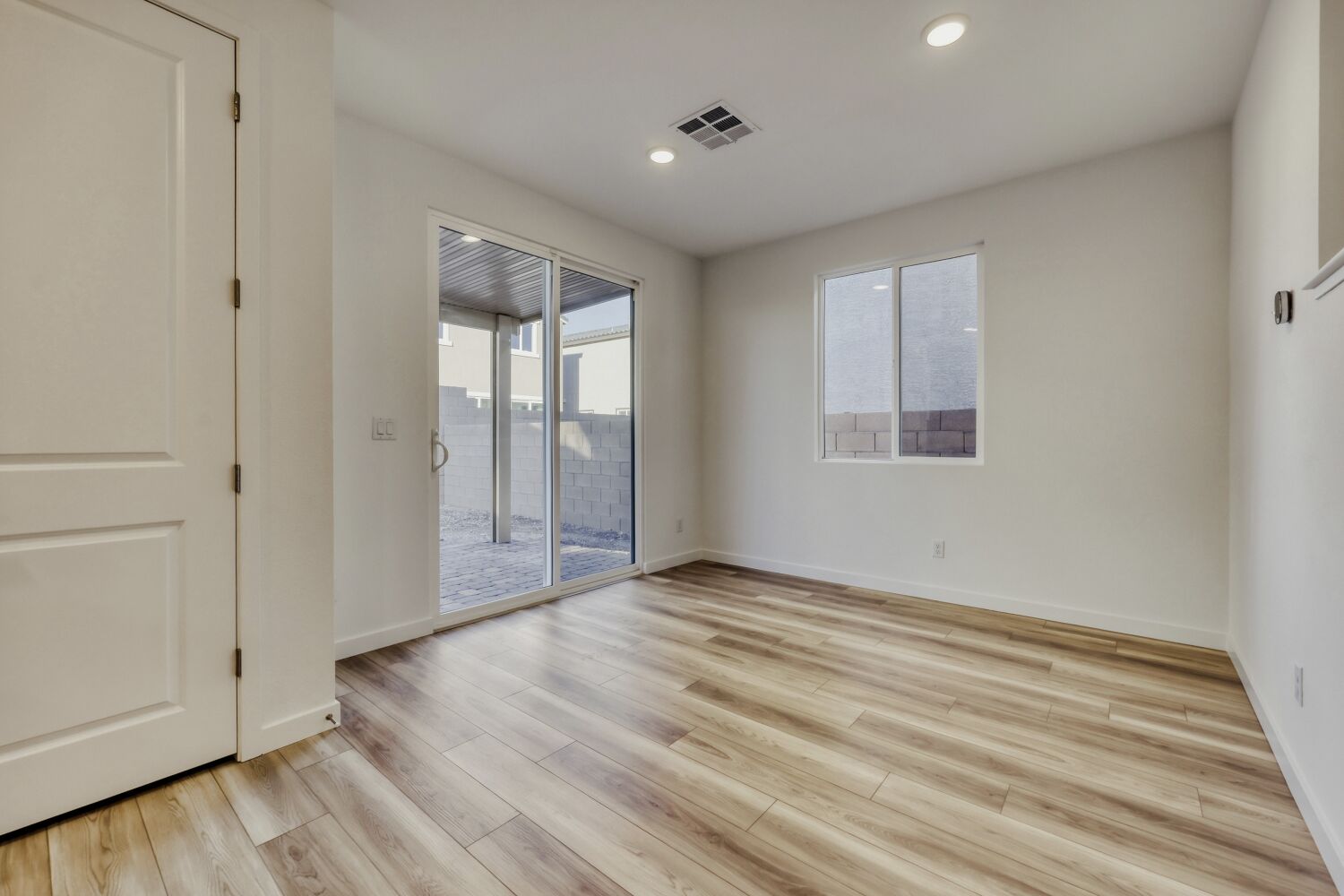 A room with a wood floor and a glass door.