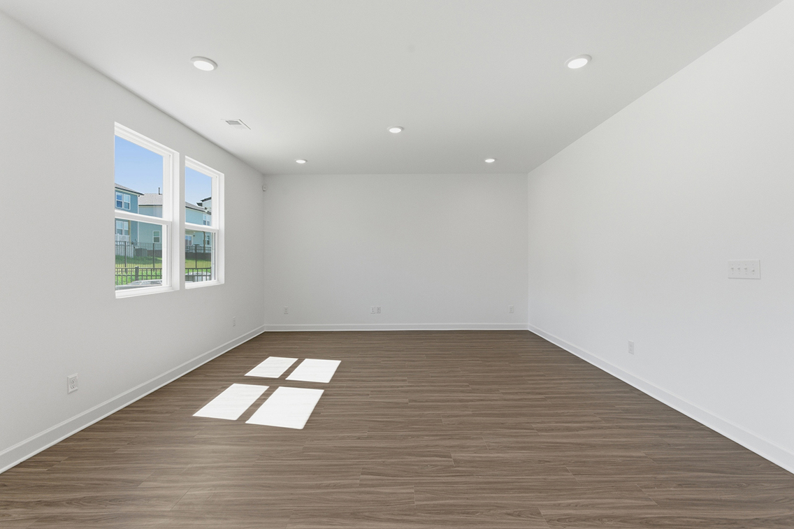 A room with a wood floor and windows.