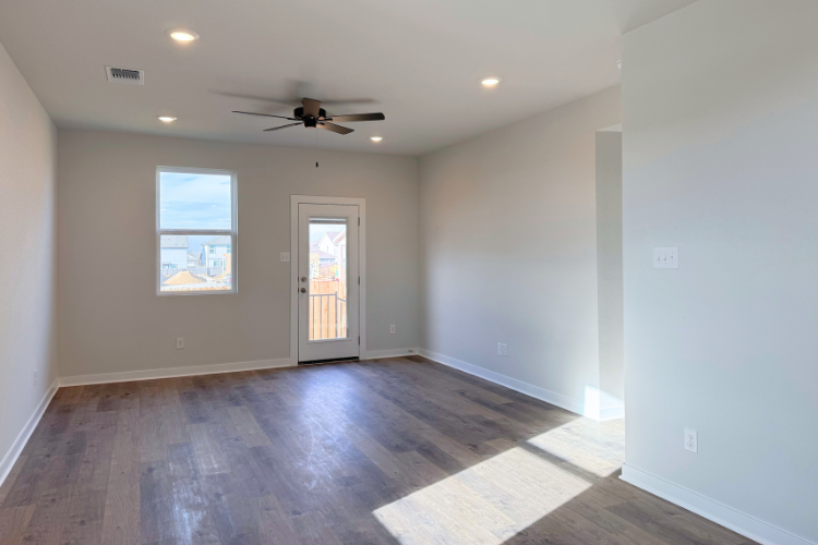 A room with a wood floor and a ceiling fan.