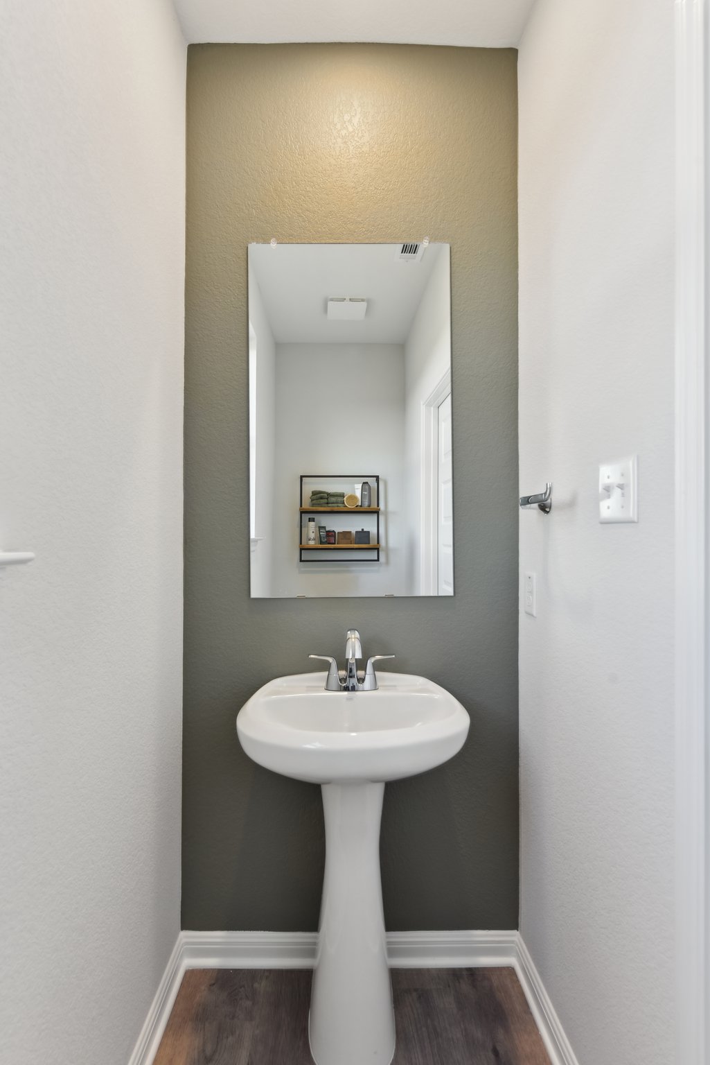 A bathroom with a mirror and sink.