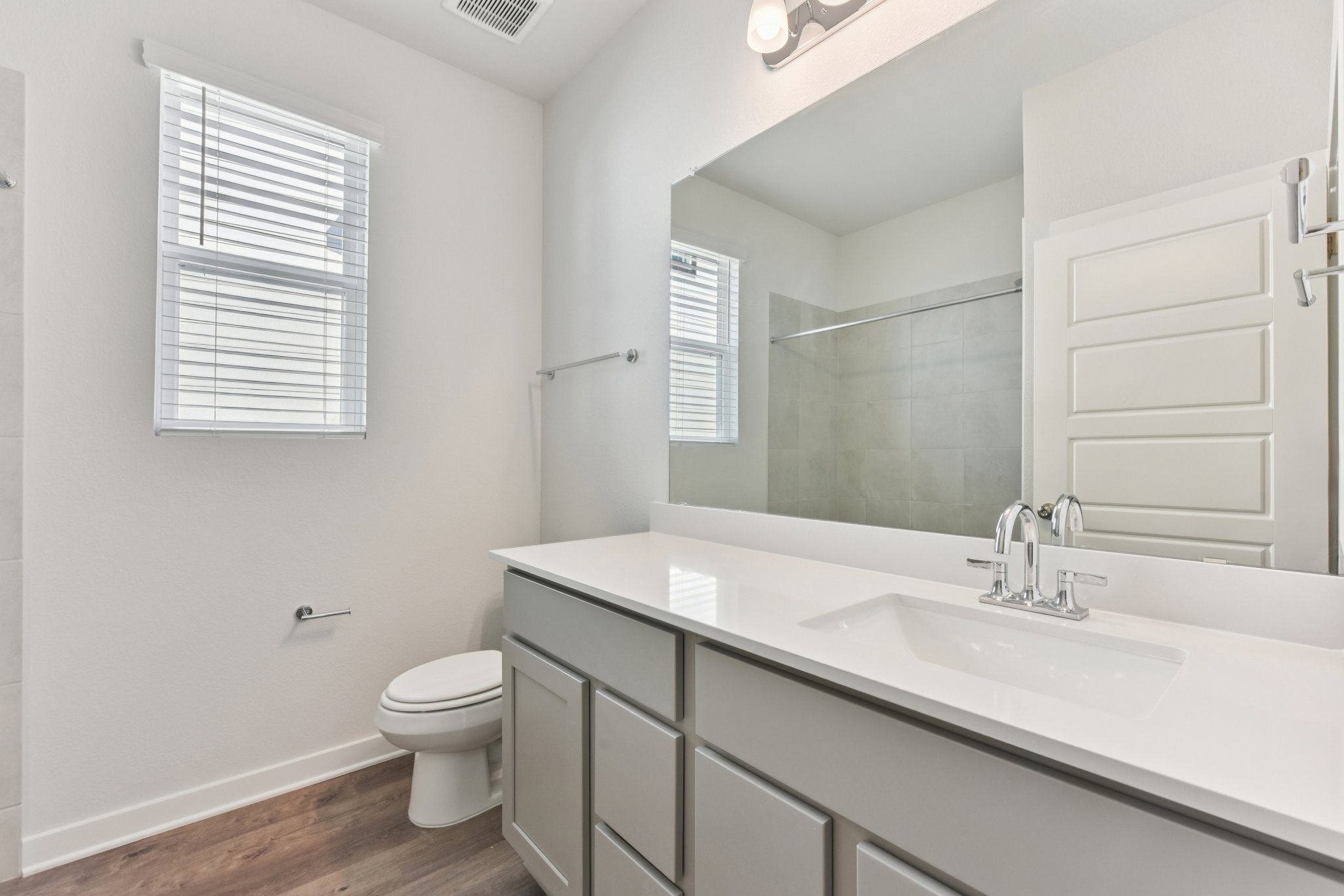 A bathroom with a large mirror.