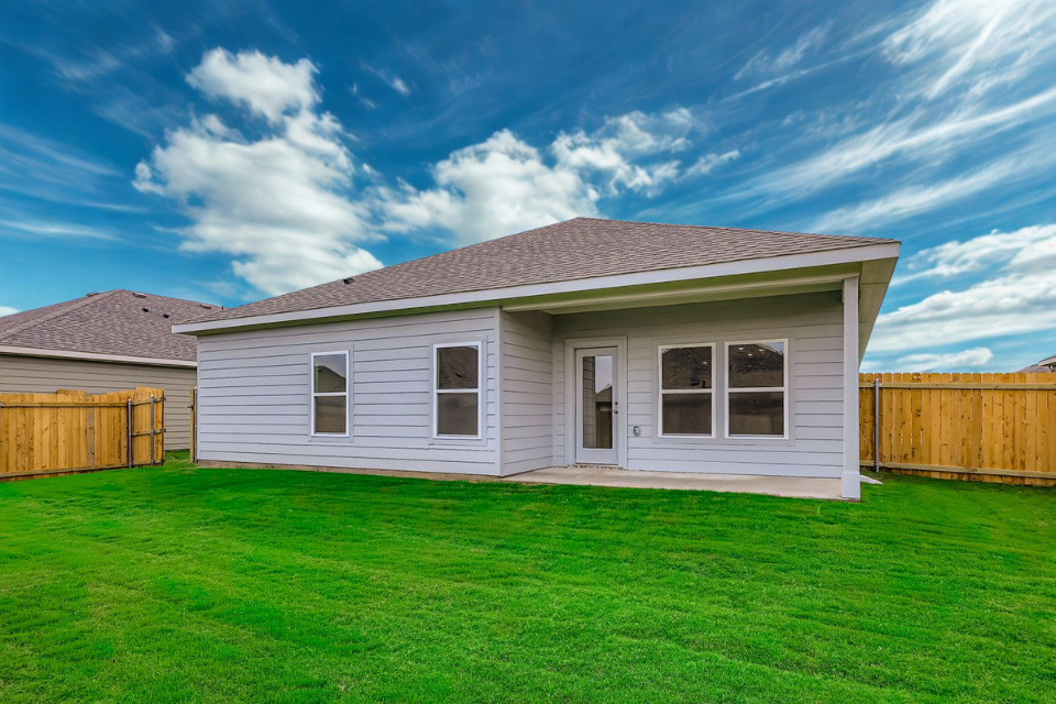 A house with a fence and grass.
