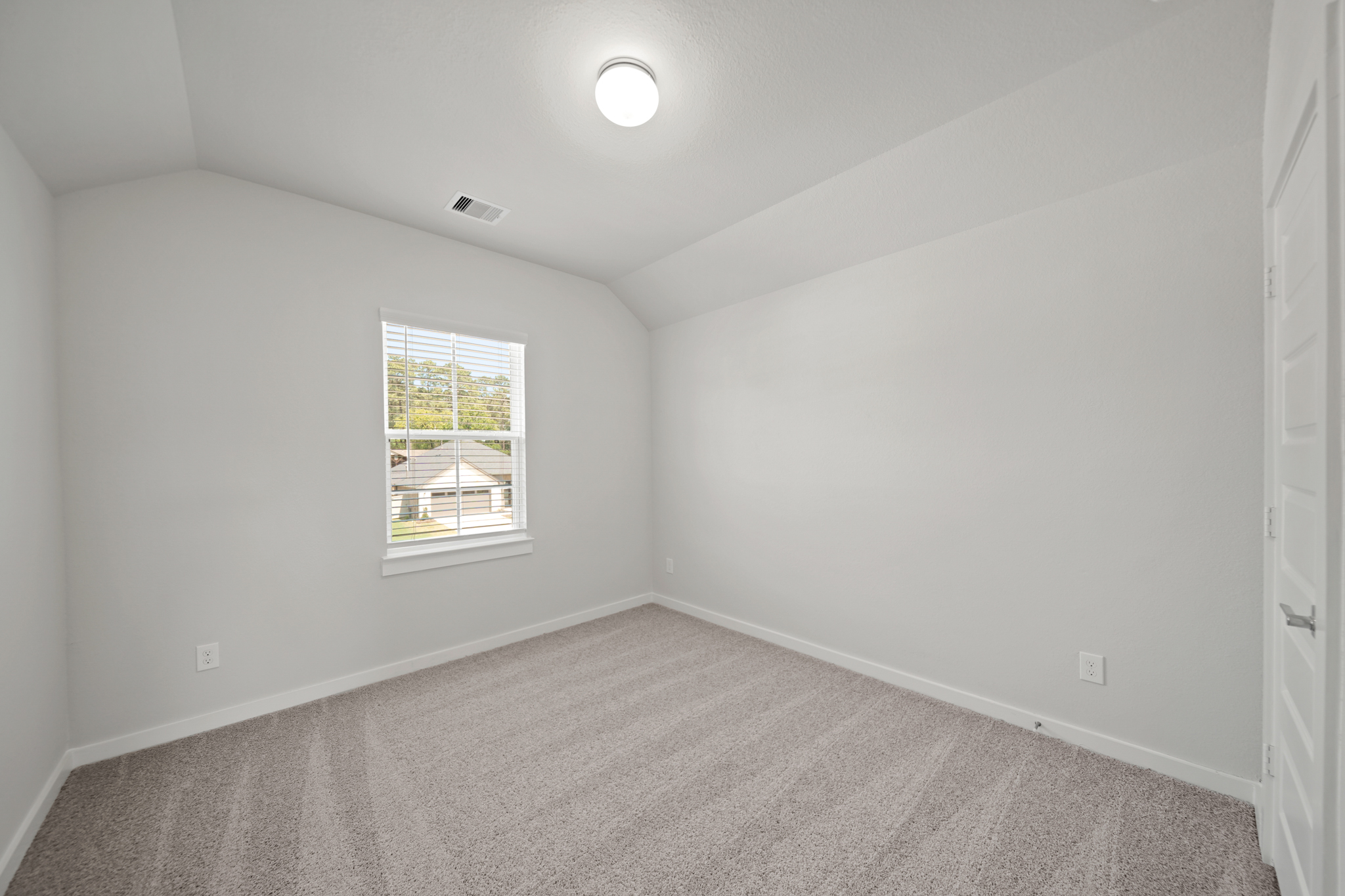 A room with a window and a carpet.