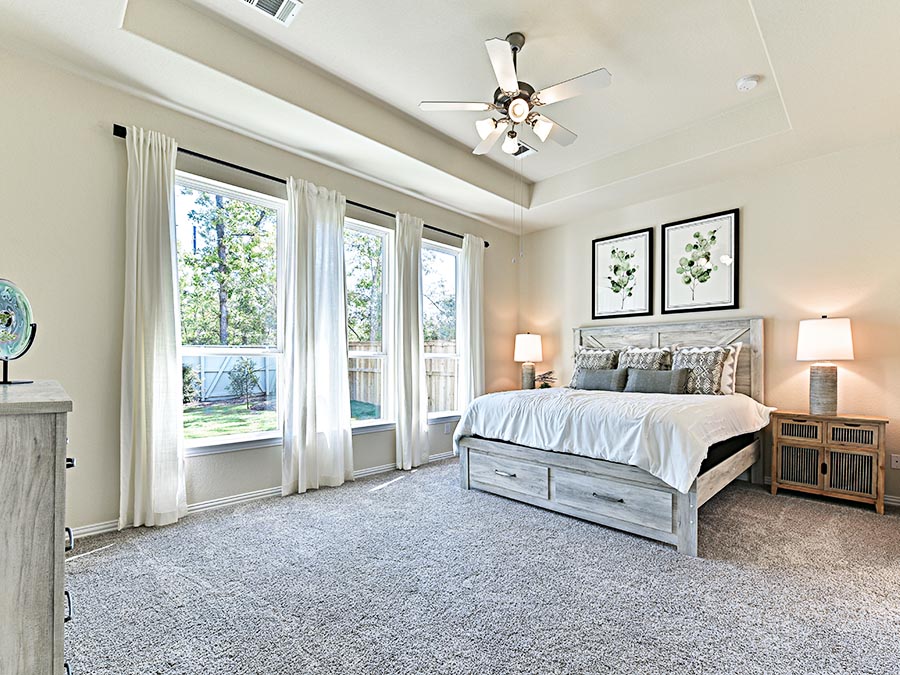 A bedroom with a large window.