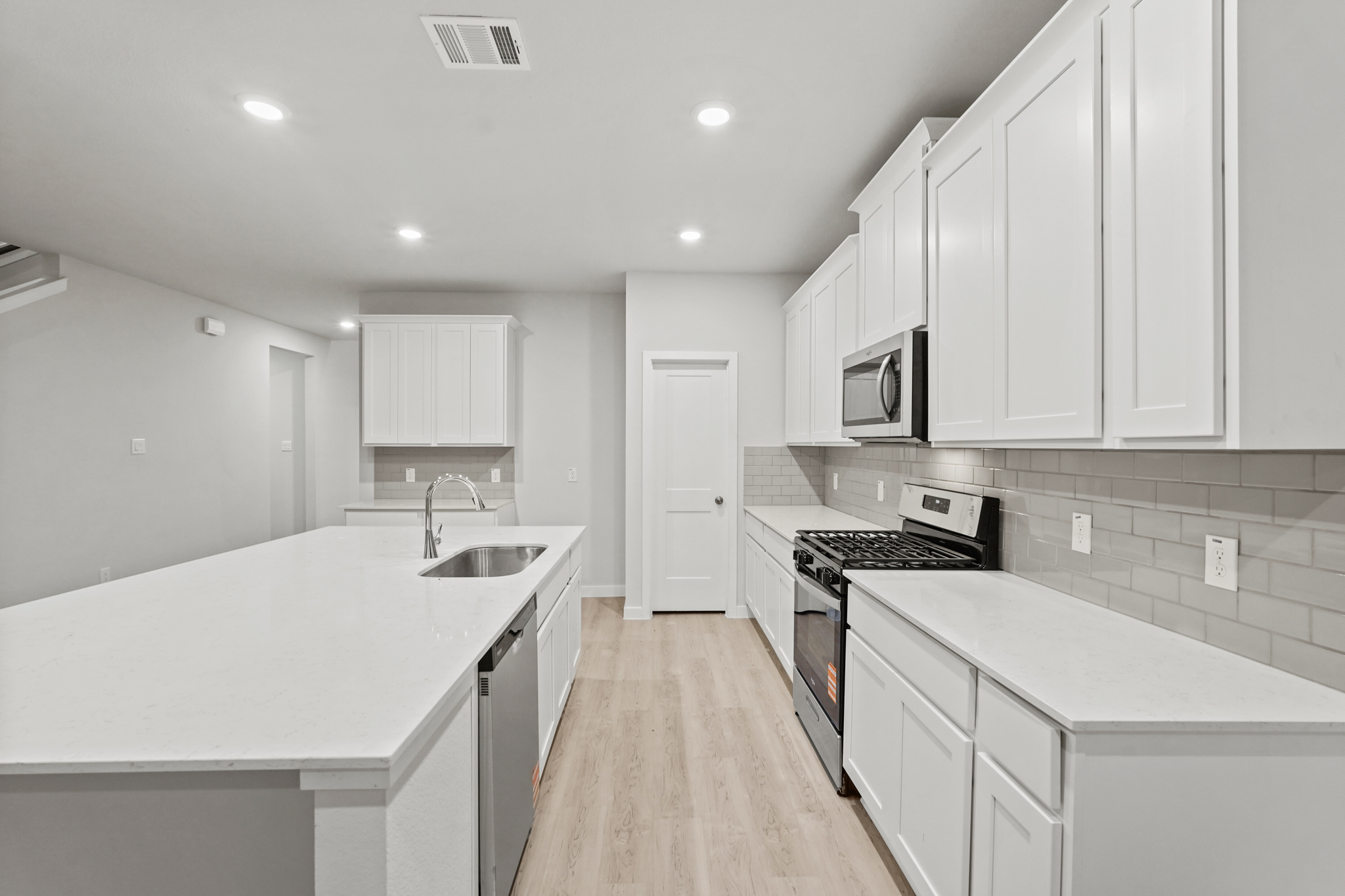 A kitchen with white cabinets.