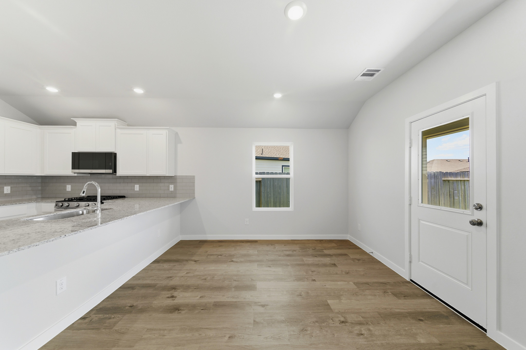 A kitchen with white cabinets.