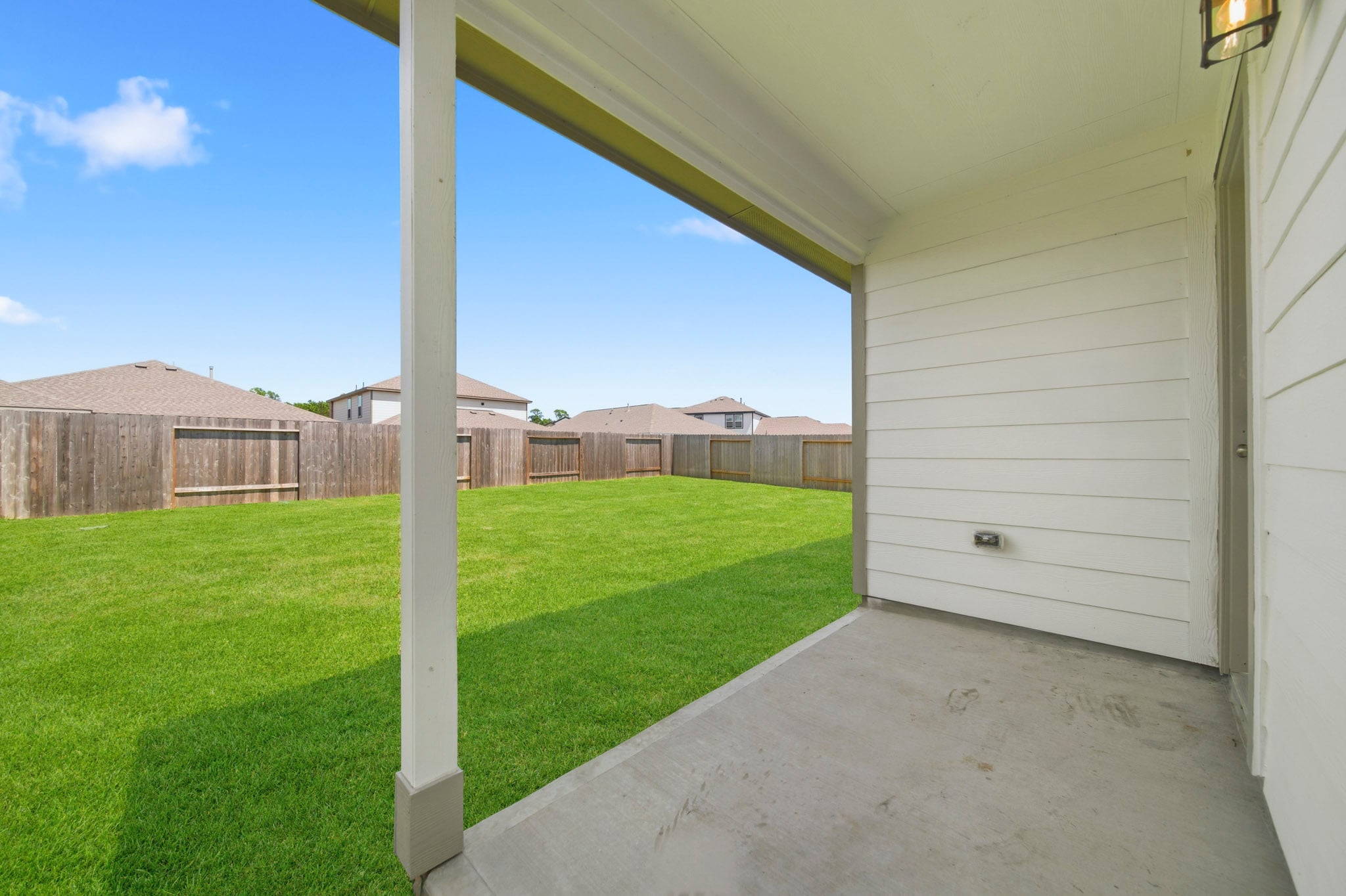 A backyard with a fence and a house.