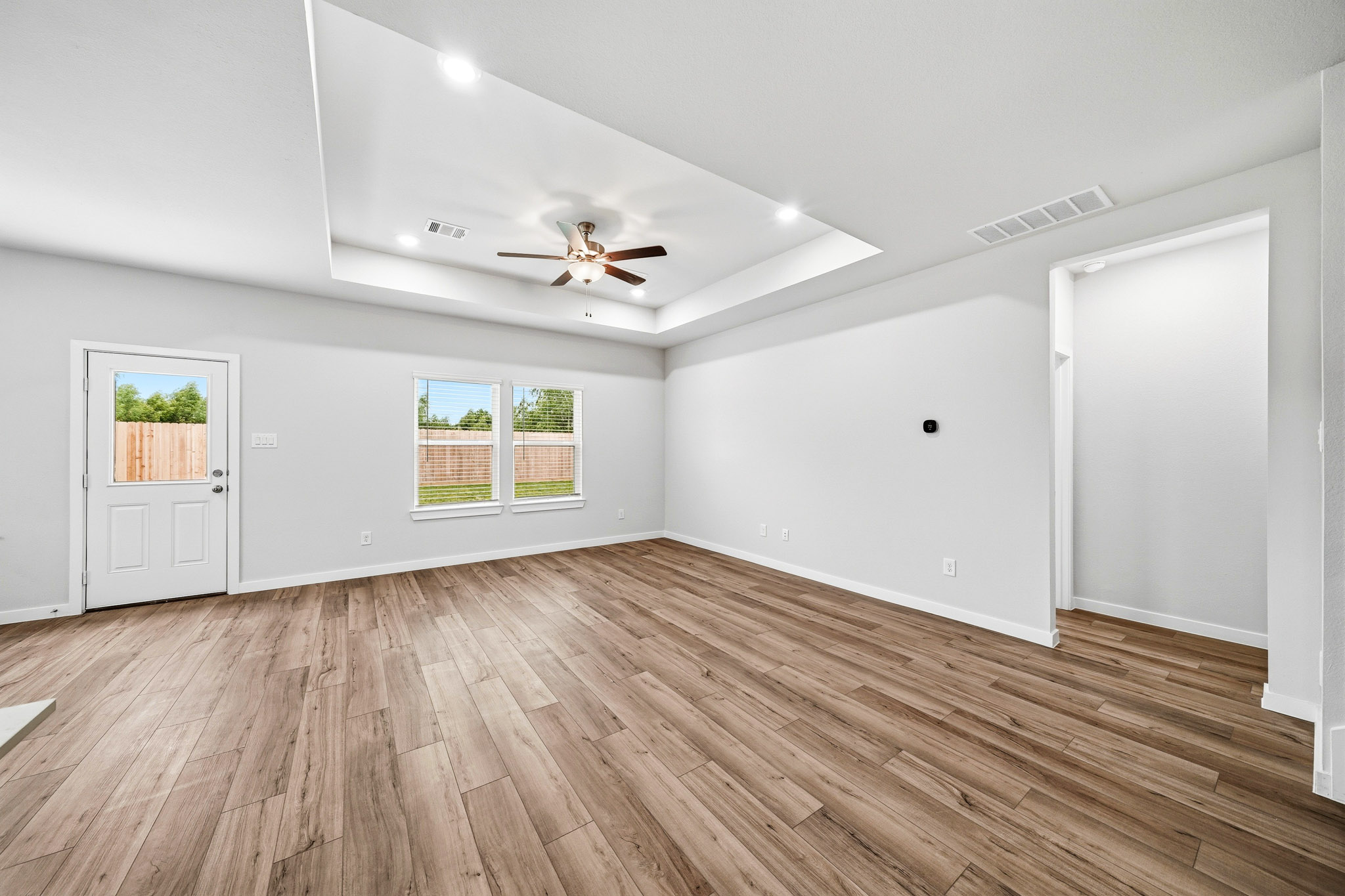 A room with a wood floor and a ceiling fan.