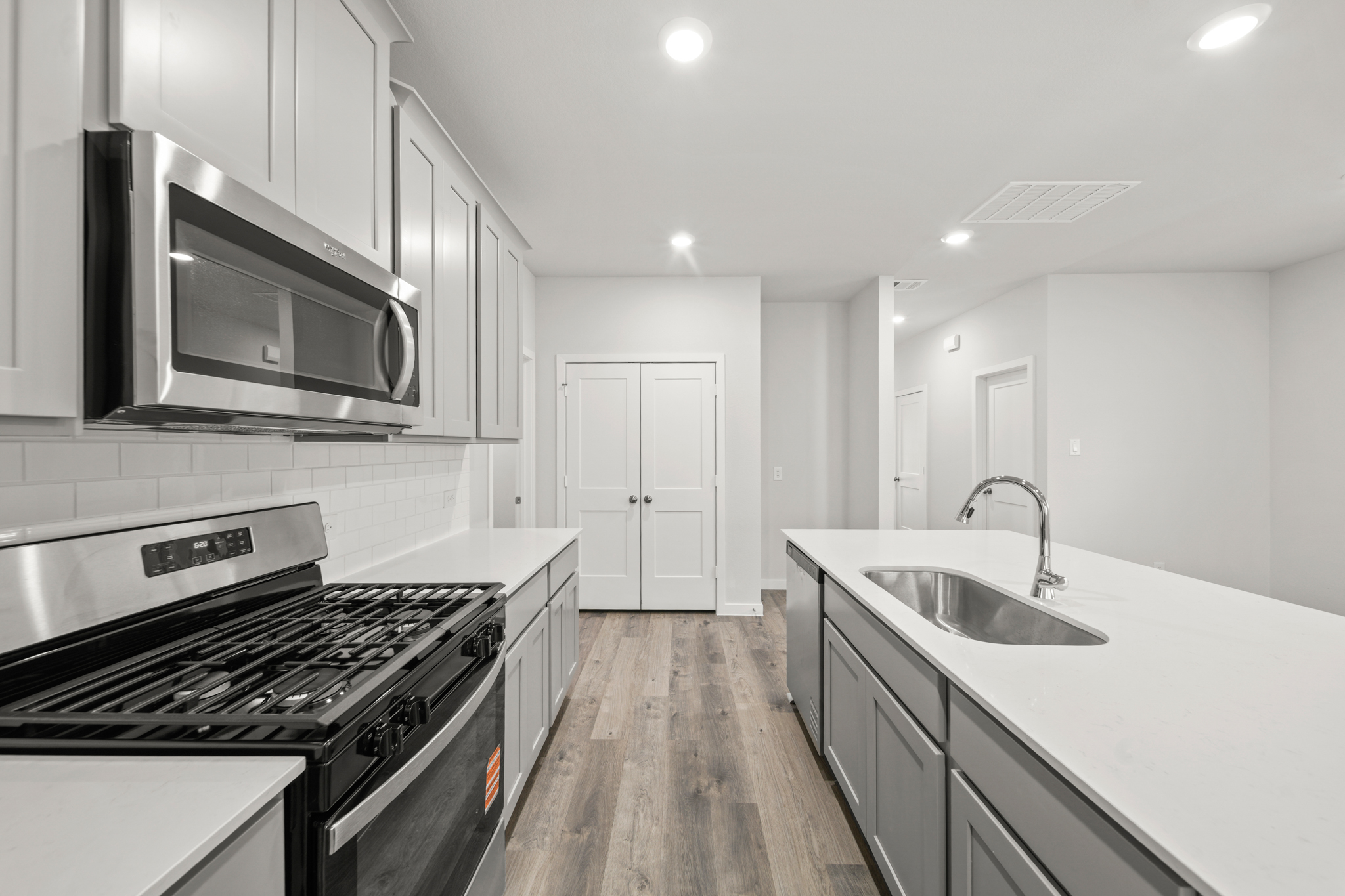 A kitchen with white cabinets.