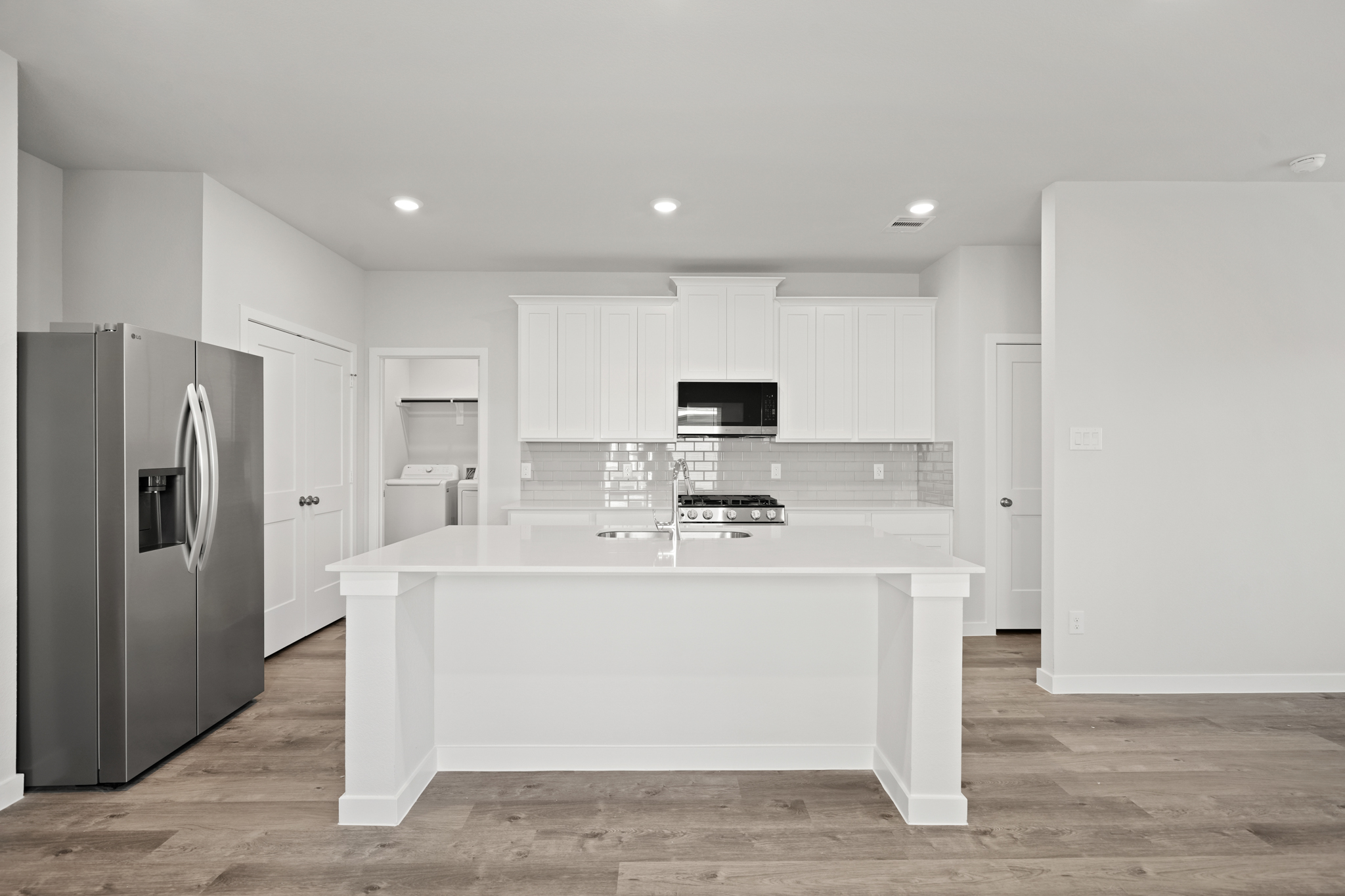 A kitchen with white cabinets.