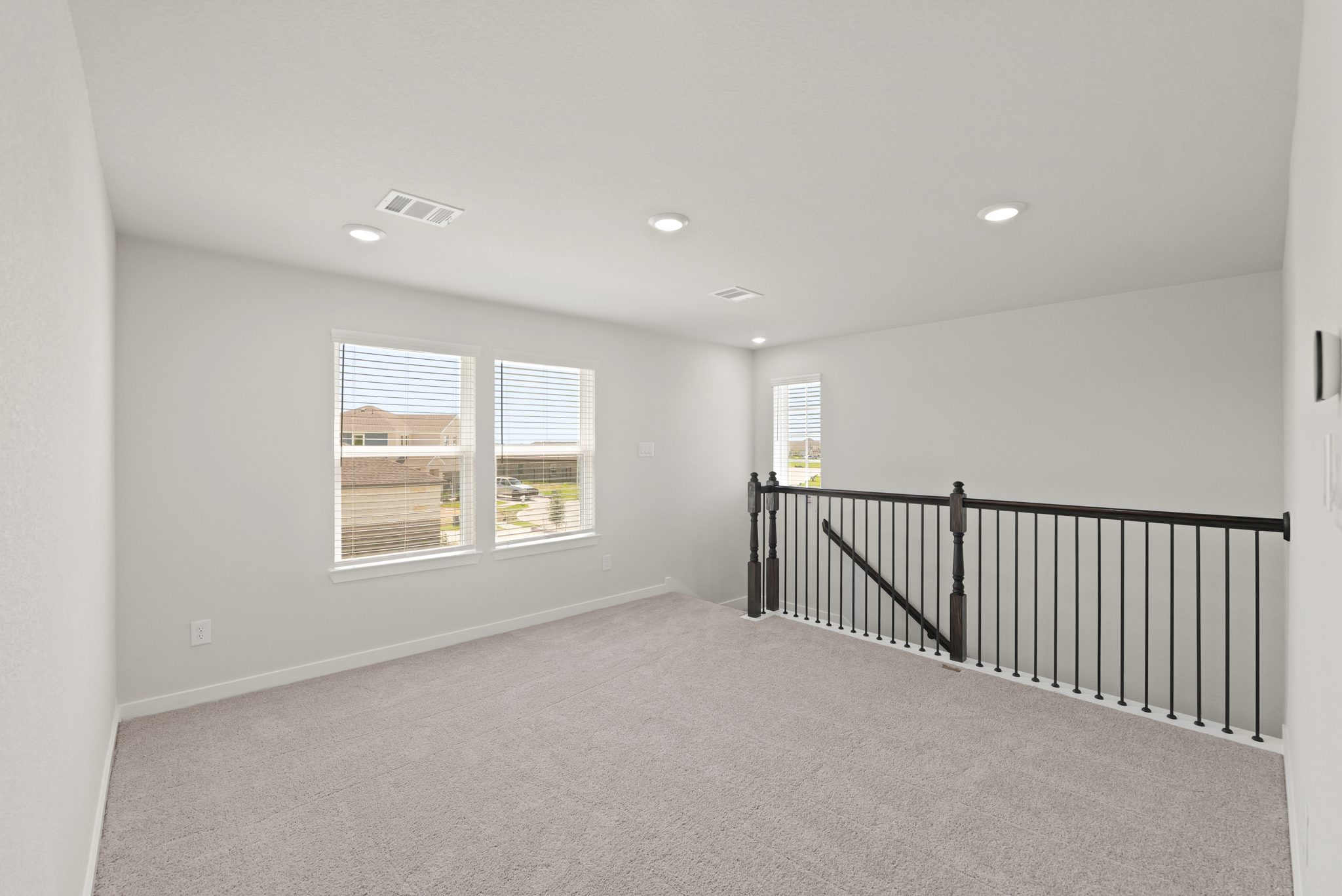 A room with a railing and windows.