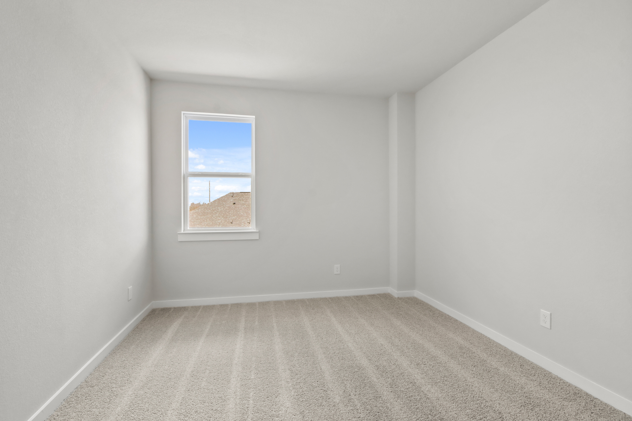 A room with a window and a carpet.