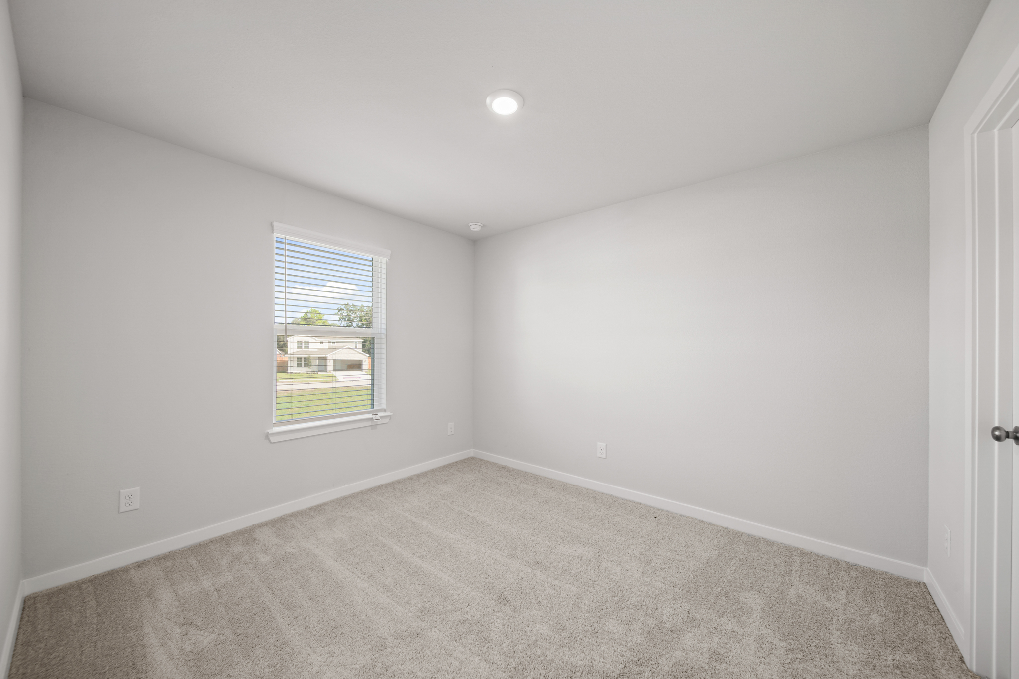 A room with a window and carpet.