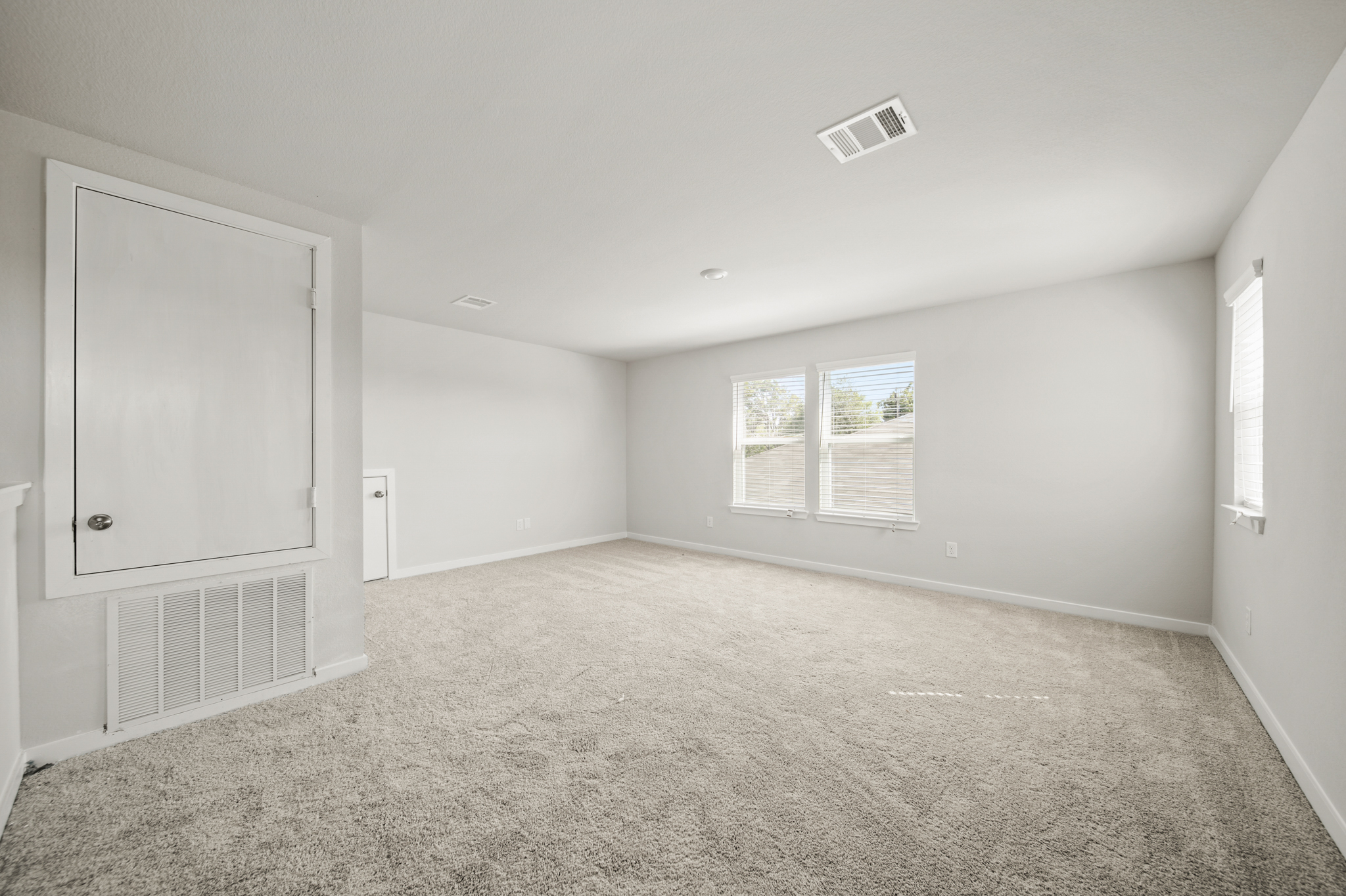 A room with a carpet and a window.