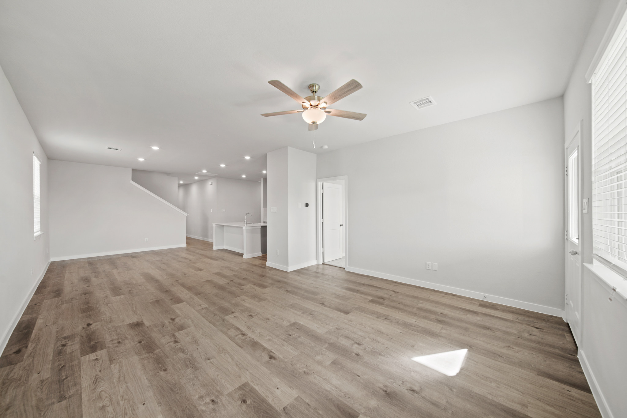 A room with a wood floor and a ceiling fan.