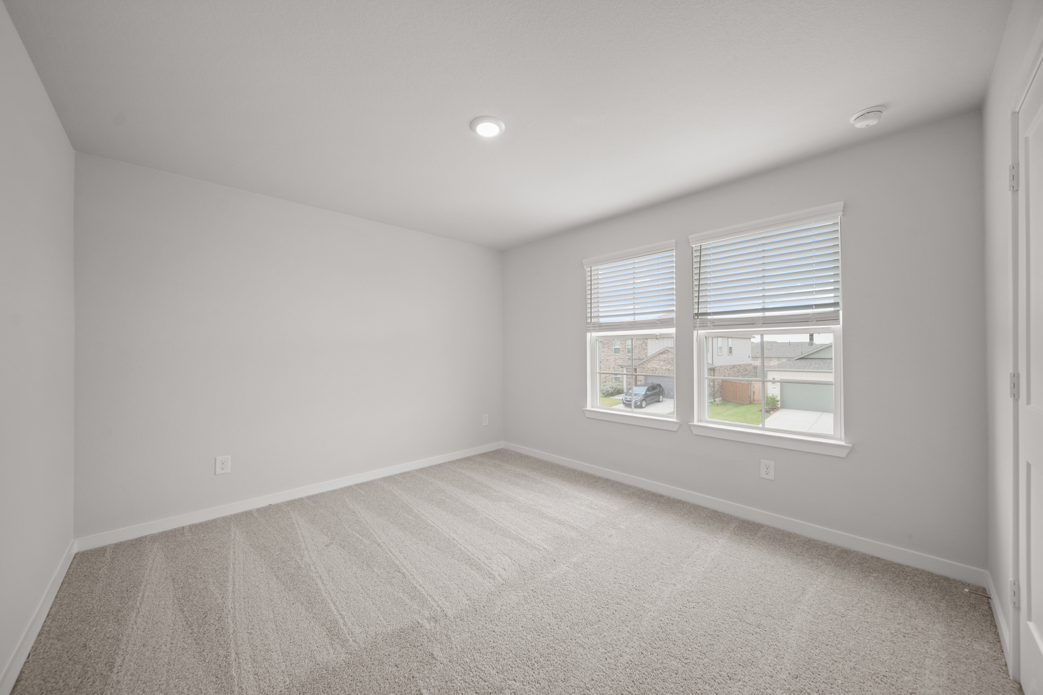 A room with a carpet and windows.