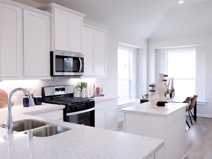 A kitchen with white cabinets.