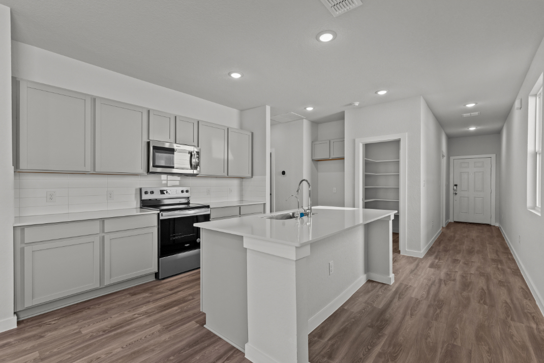 A kitchen with white cabinets.