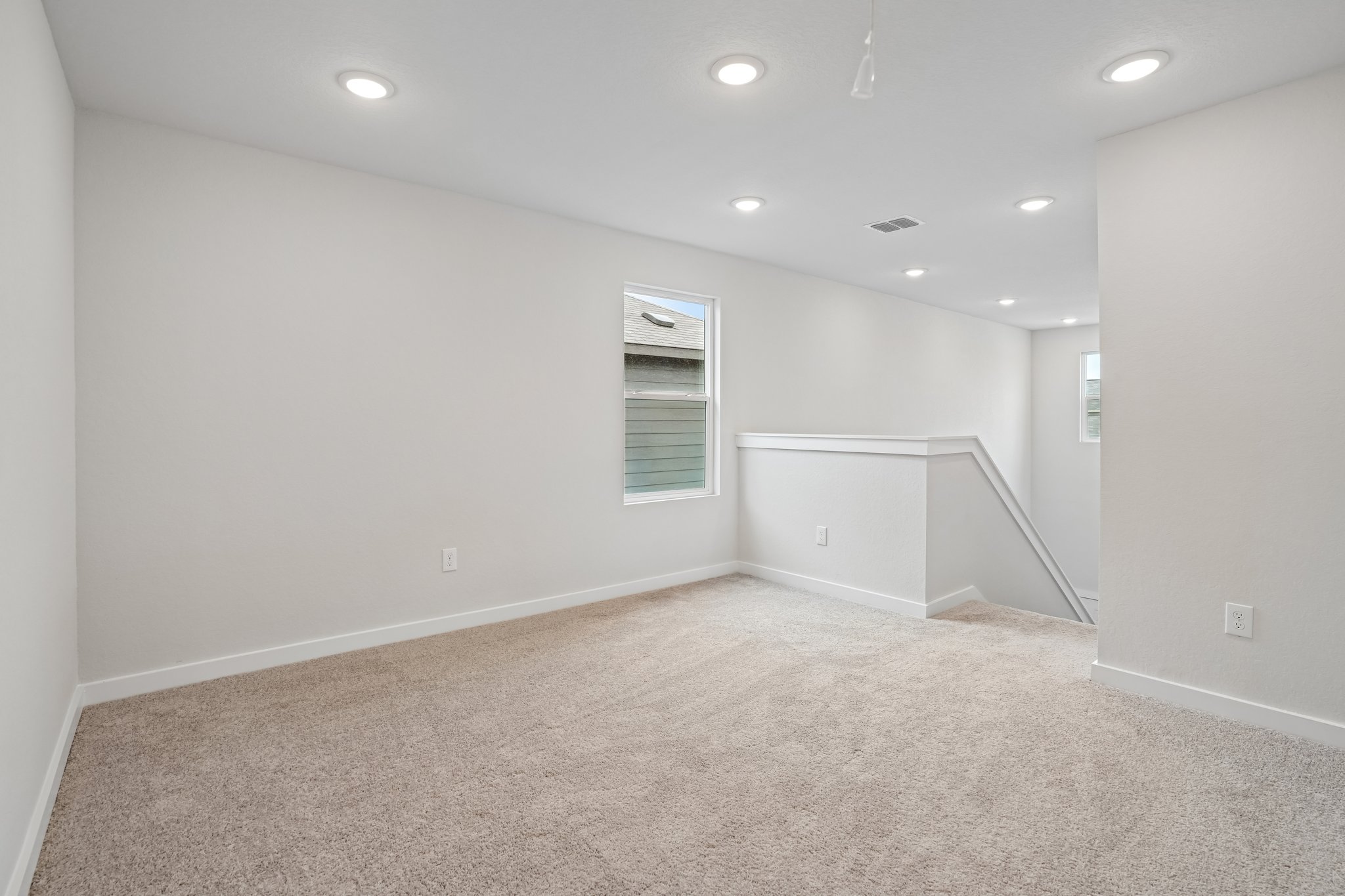 A room with a carpet and a window.