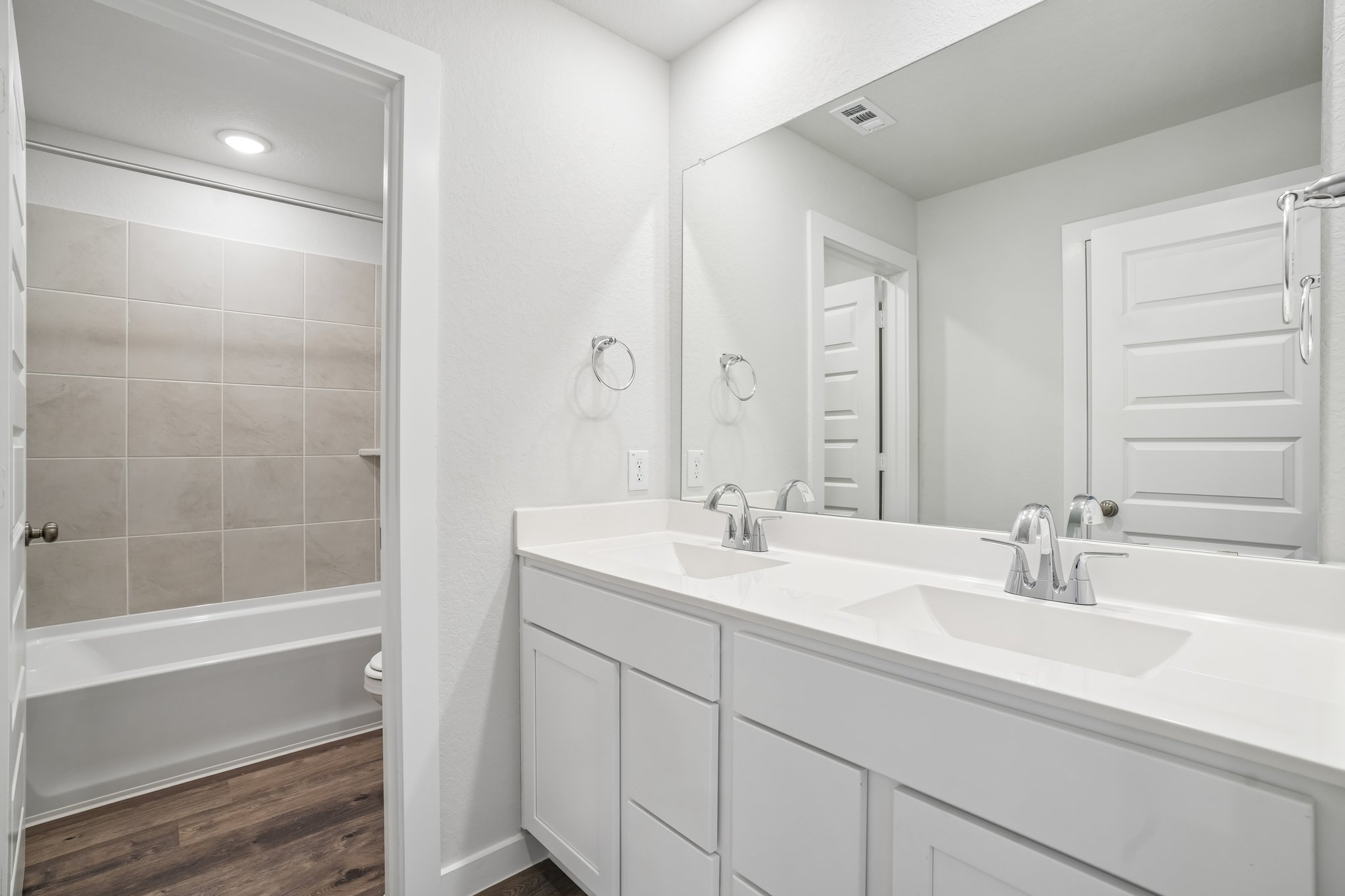A bathroom with a tub sink and a mirror.