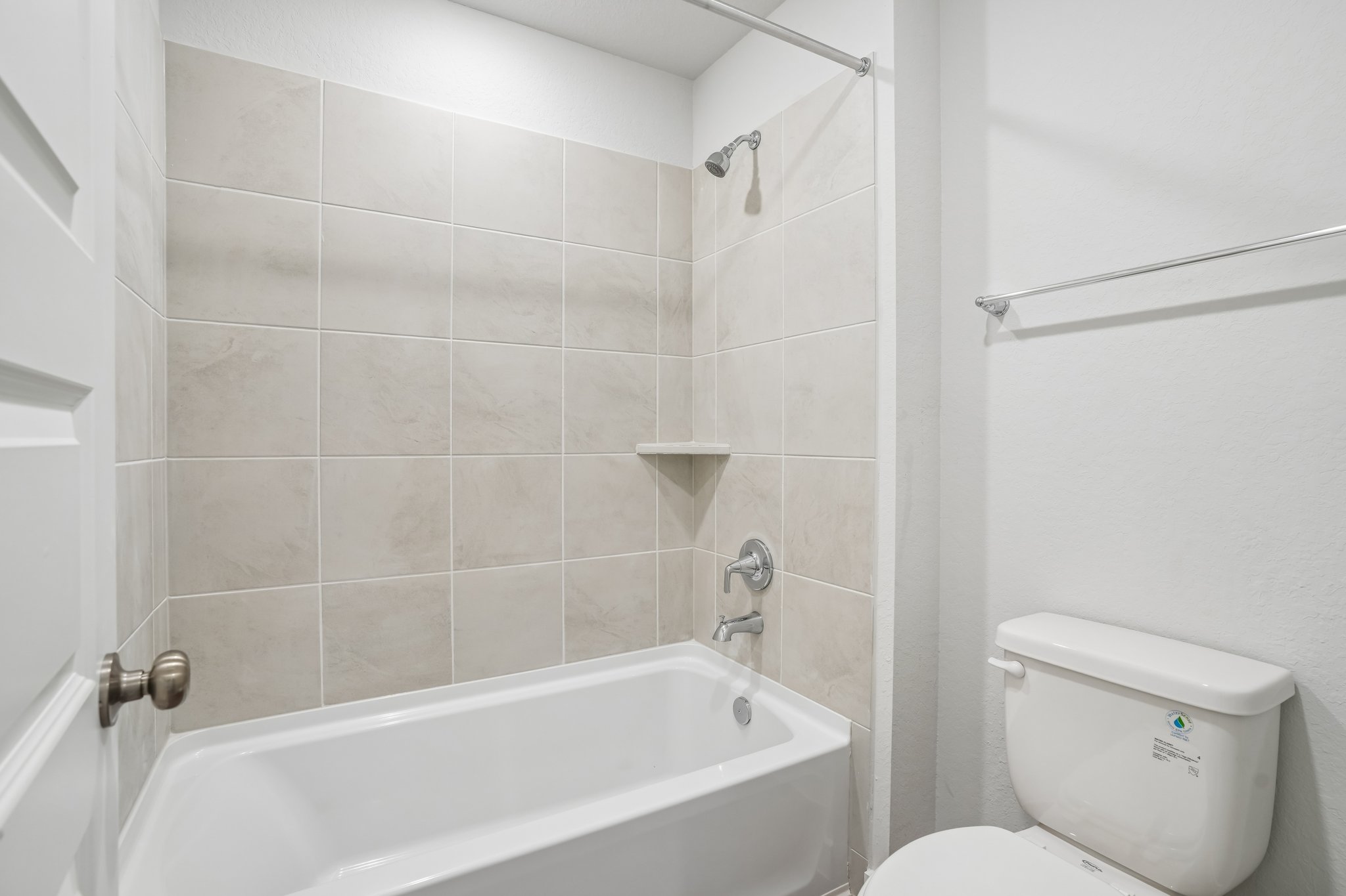 A bathroom with a toilet and bathtub.