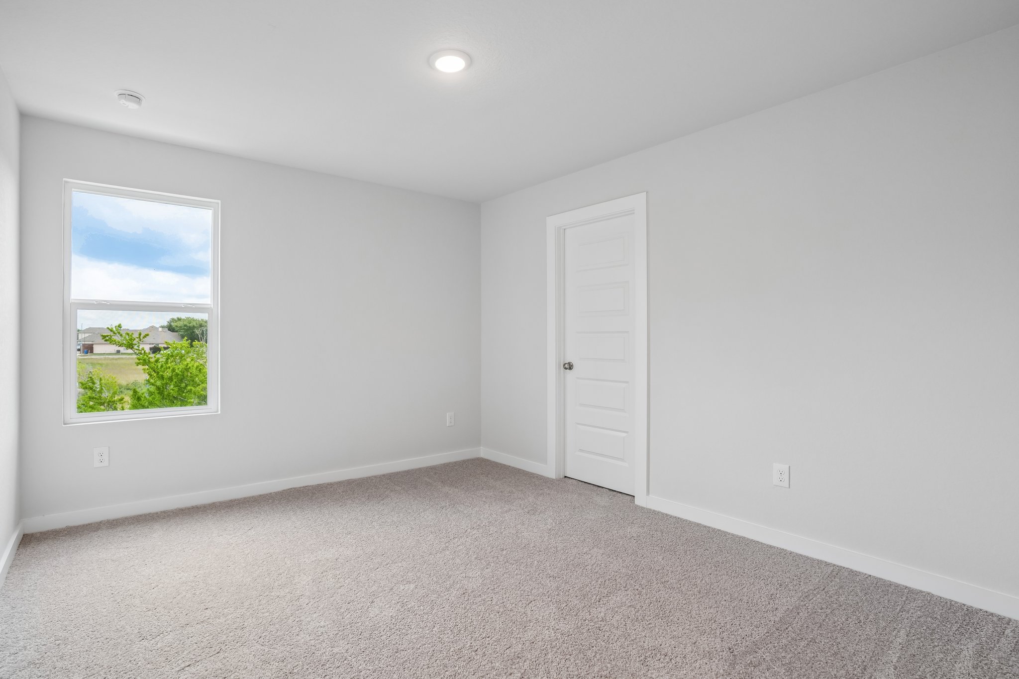 A room with white walls and a window.