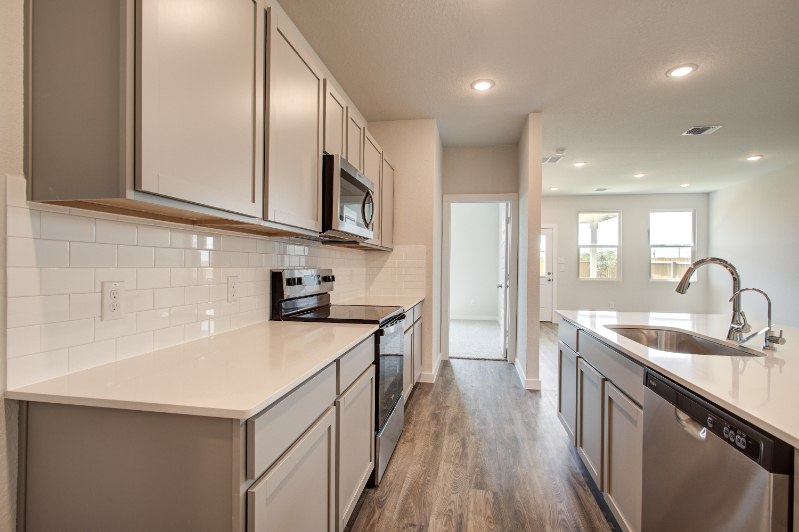 A kitchen with white cabinets.