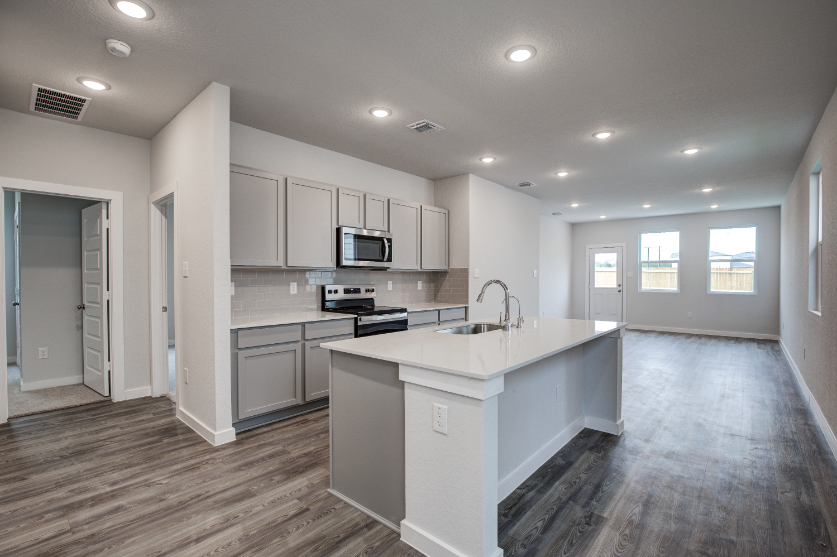 A kitchen with white cabinets.