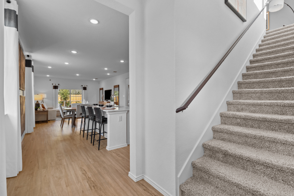 A room with a staircase and chairs.